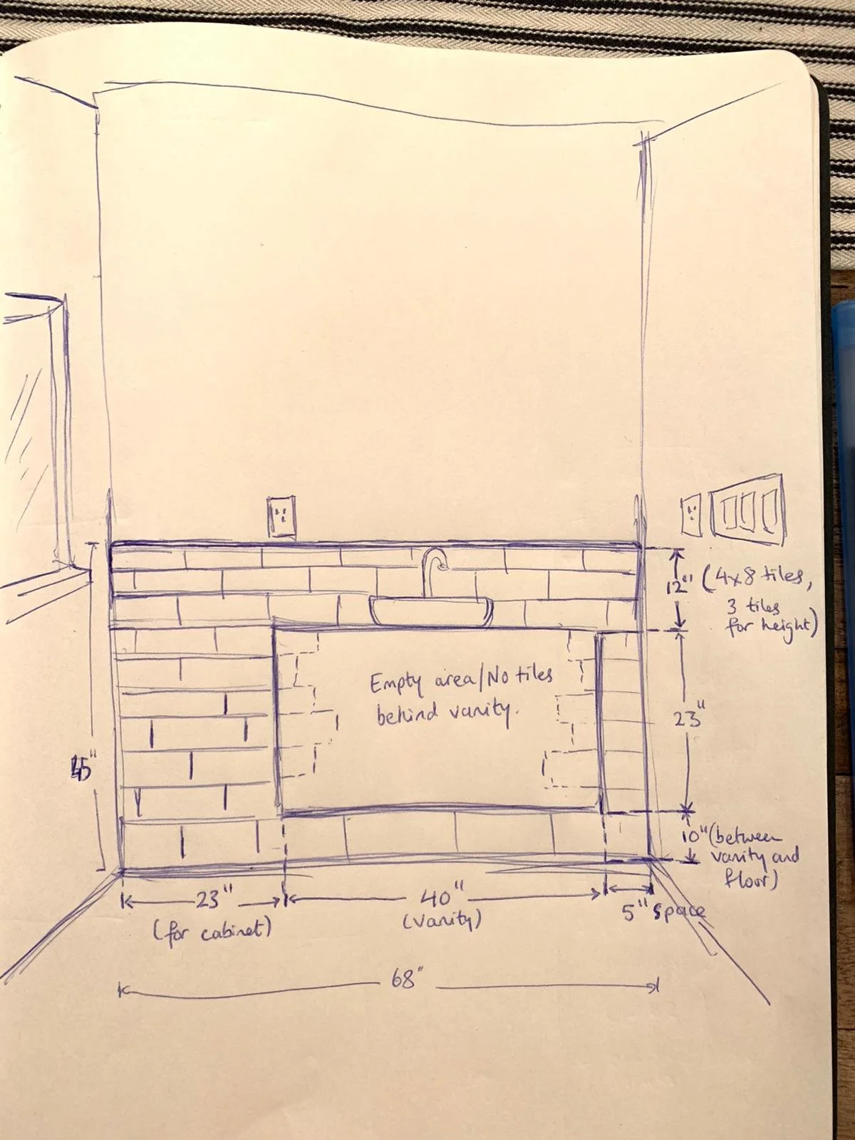 A hand drawn sketch of a bathroom vanity layout with measurements. Shows a cabinet measuring 23 inch wide, a 40 inch wide vanity a sink, and various electrical outlets. Various notes regarding measurements and design.
