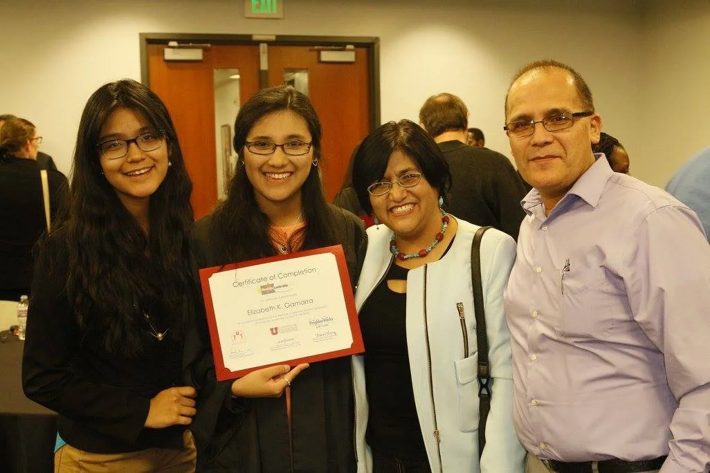 Group of four smiling people at an indoor event, with one holding a certificate of completion.