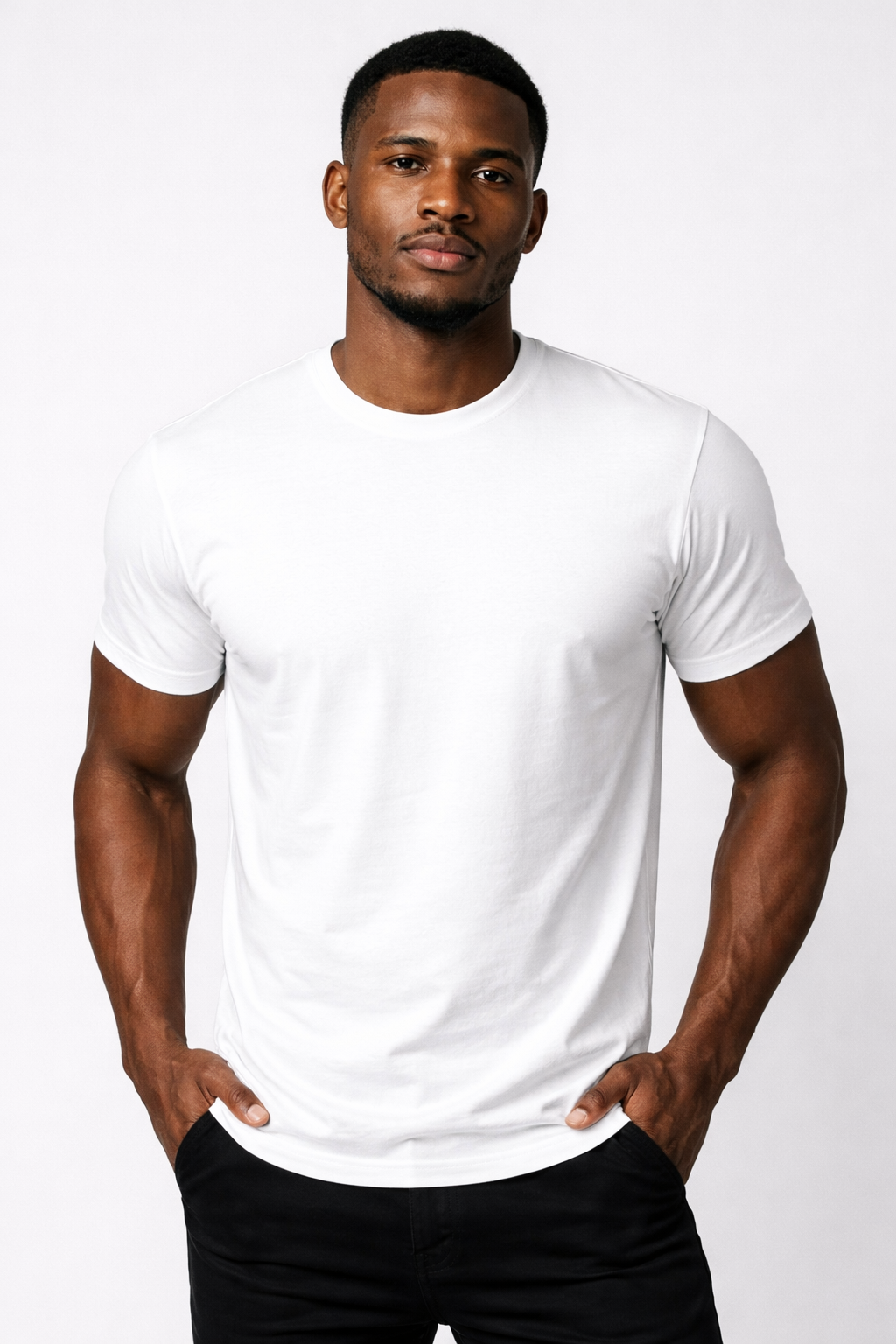 A young man with short black hair and a beard, wearing a plain white t-shirt and black pants, standing against a white background.