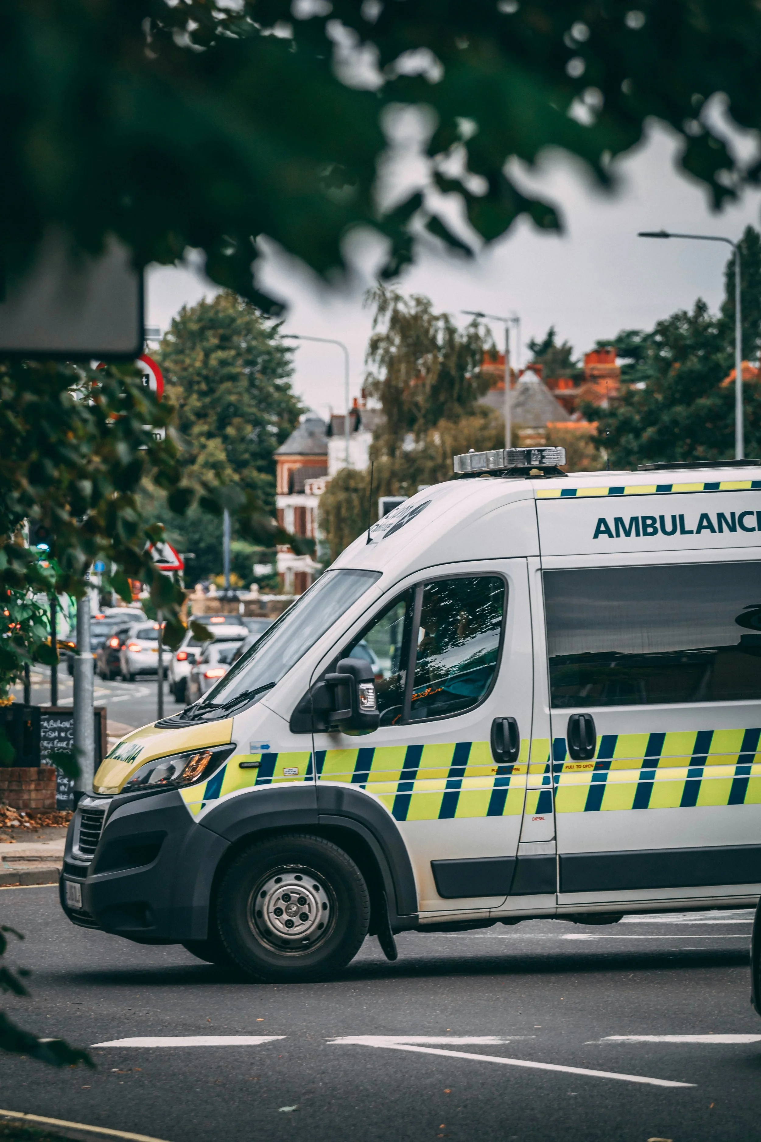 A white ambulance with reflective yellow and blue stripes.