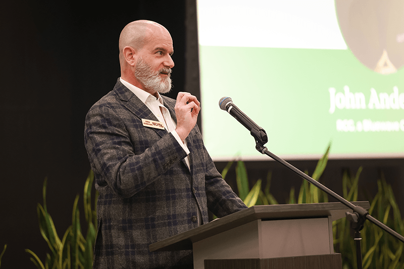 Johnny Anderson speaking at a podium