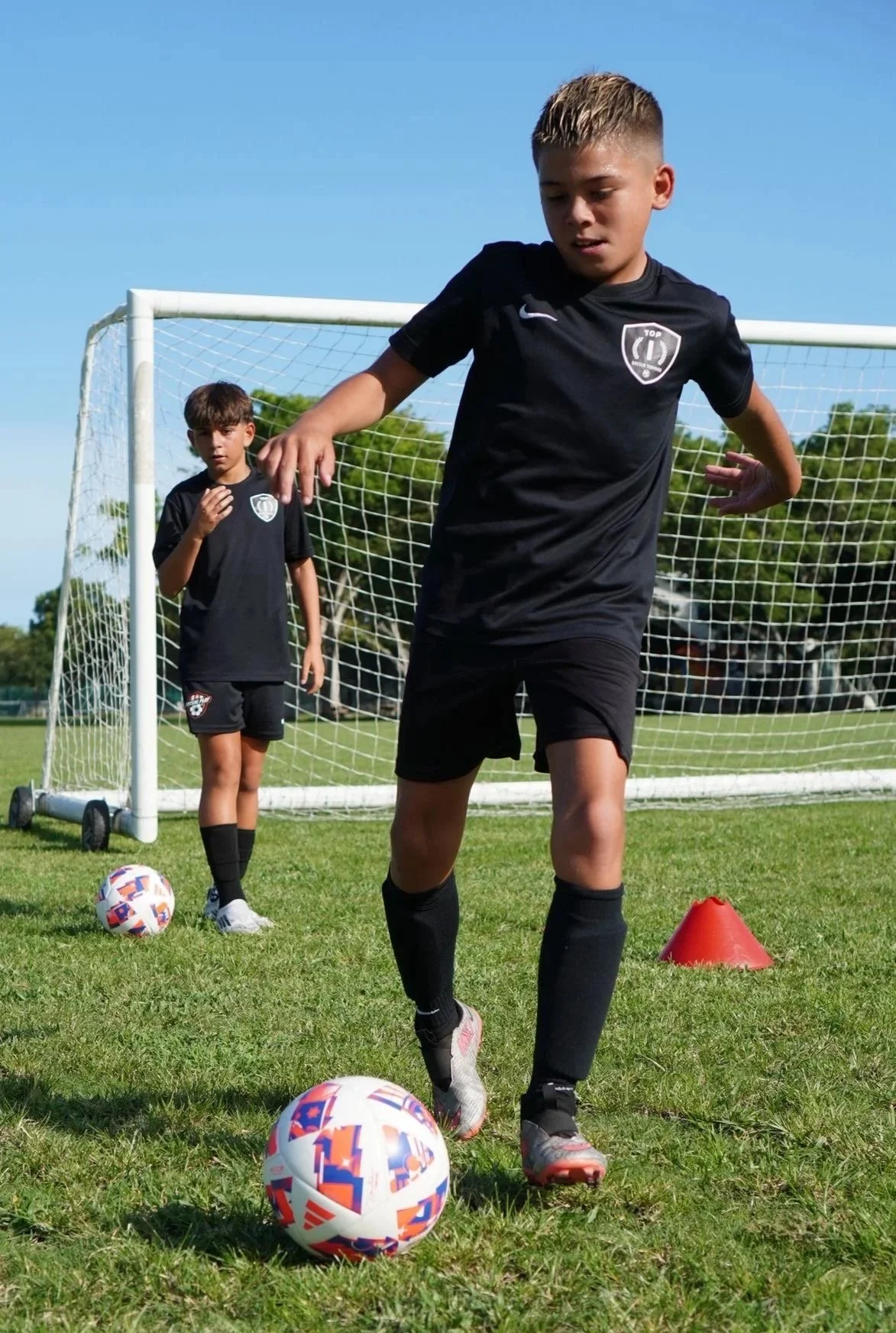 Players participating in a Top 1 Soccer Training summer soccer camp at Coral Reef Park.