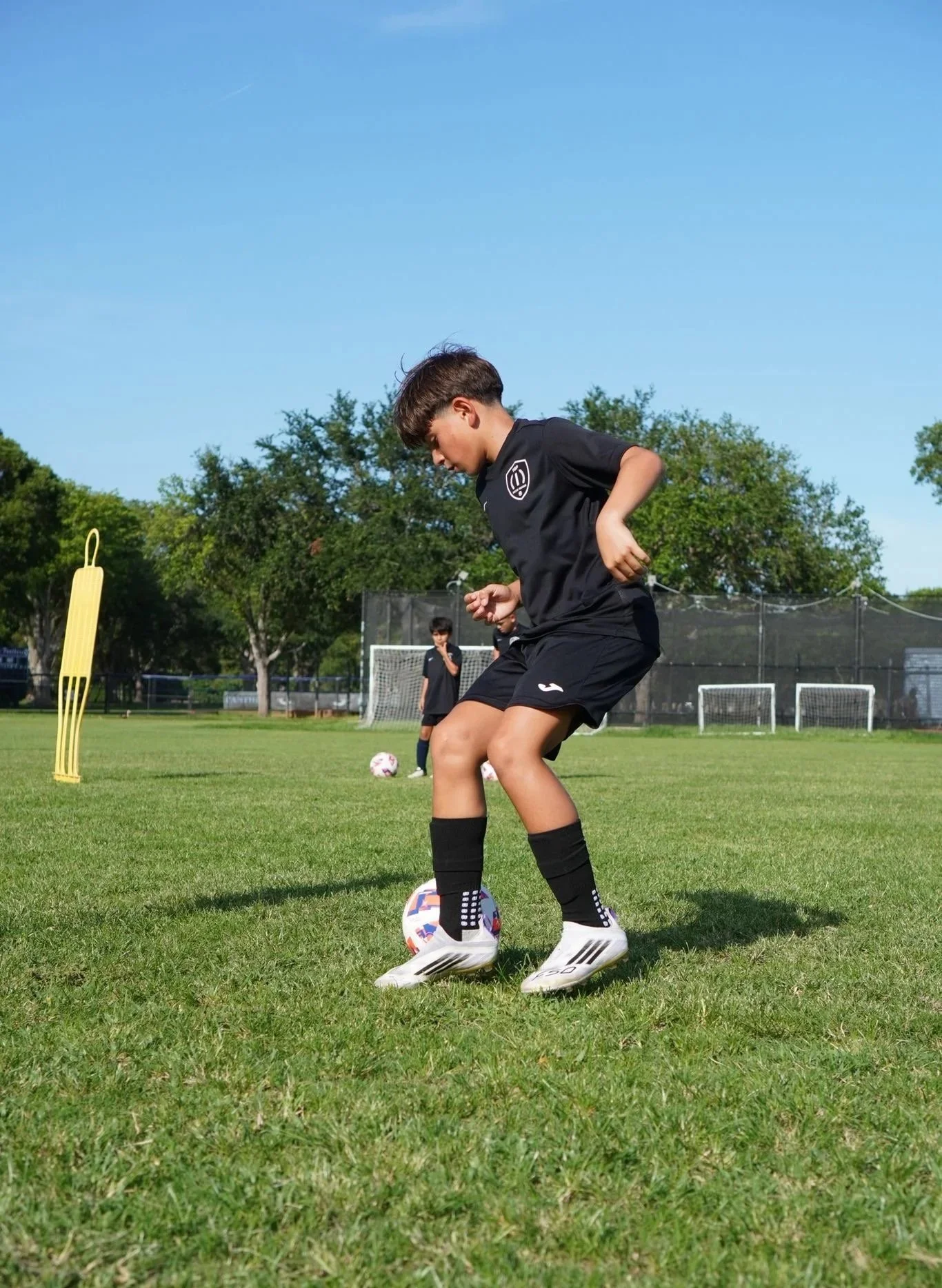 A young soccer players participating in a Top 1 Soccer Training summer soccer camp at Coral Reef Park