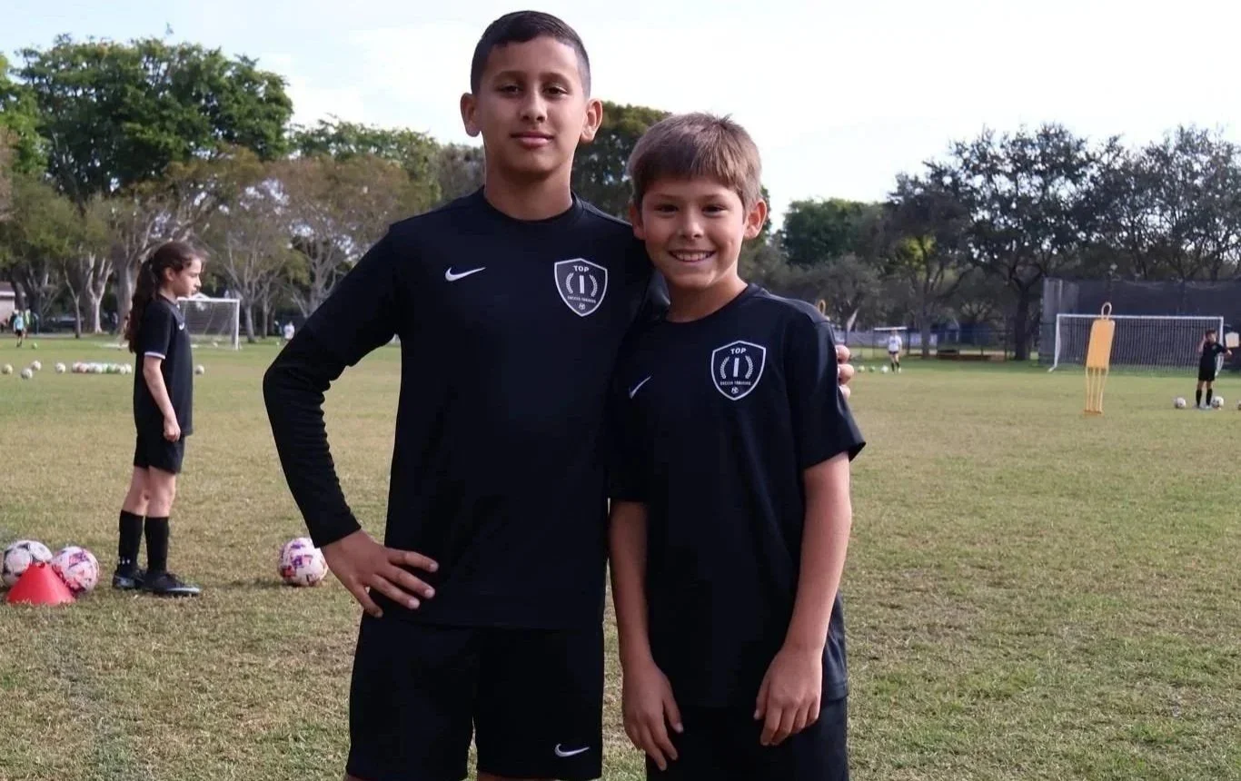 Two young players participating in a Top 1 Soccer Training winter soccer camp at Coral Reef Park