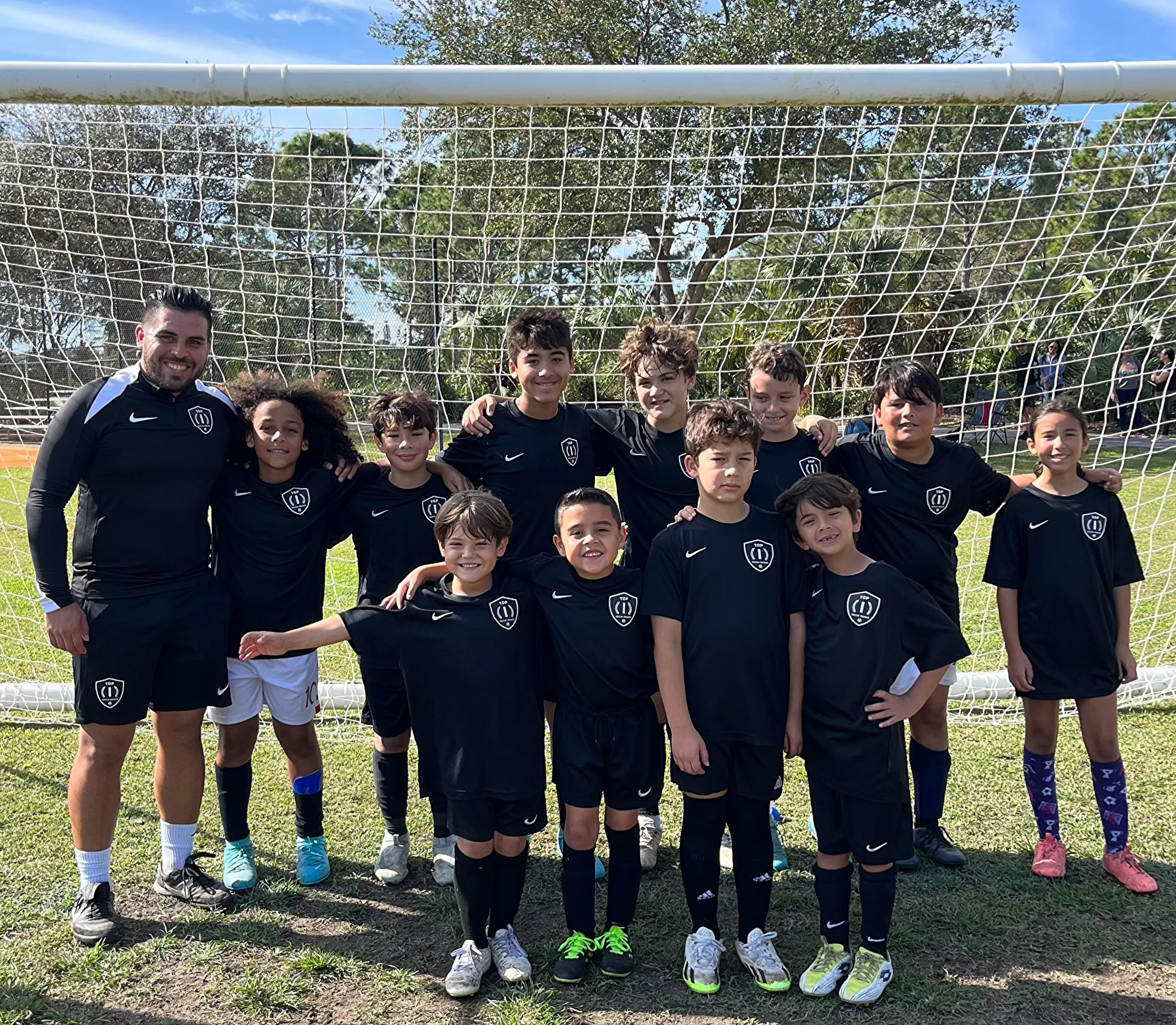Players and coaches participating in the Top 1 Soccer Training soccer clinic training session at Coral Reef Park in Miami, Florida.
