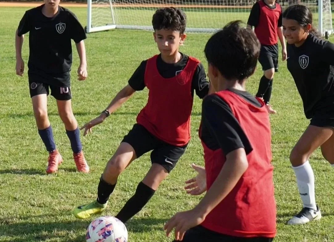 Players participating in a Top 1 Soccer Training summer soccer camp at Coral Reef Park