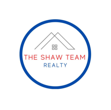 Logo for The Shaw Team Realty featuring a house outline and the company name within a blue circle.