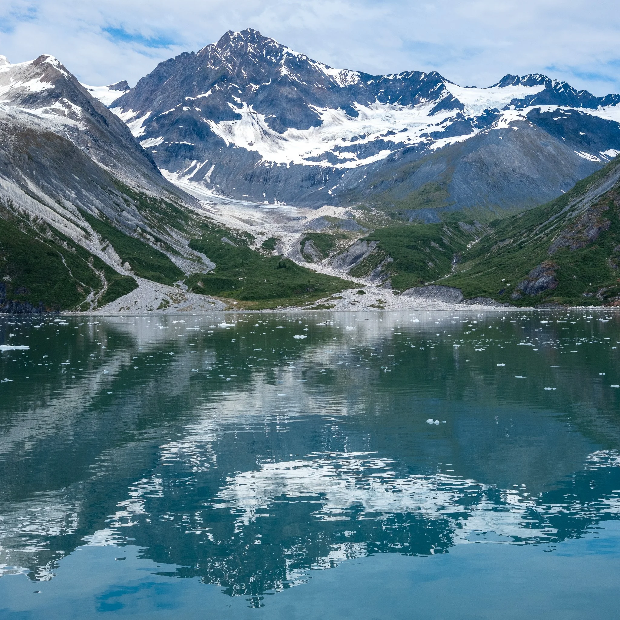 Snow-capped mountain range reflected in a calm lake