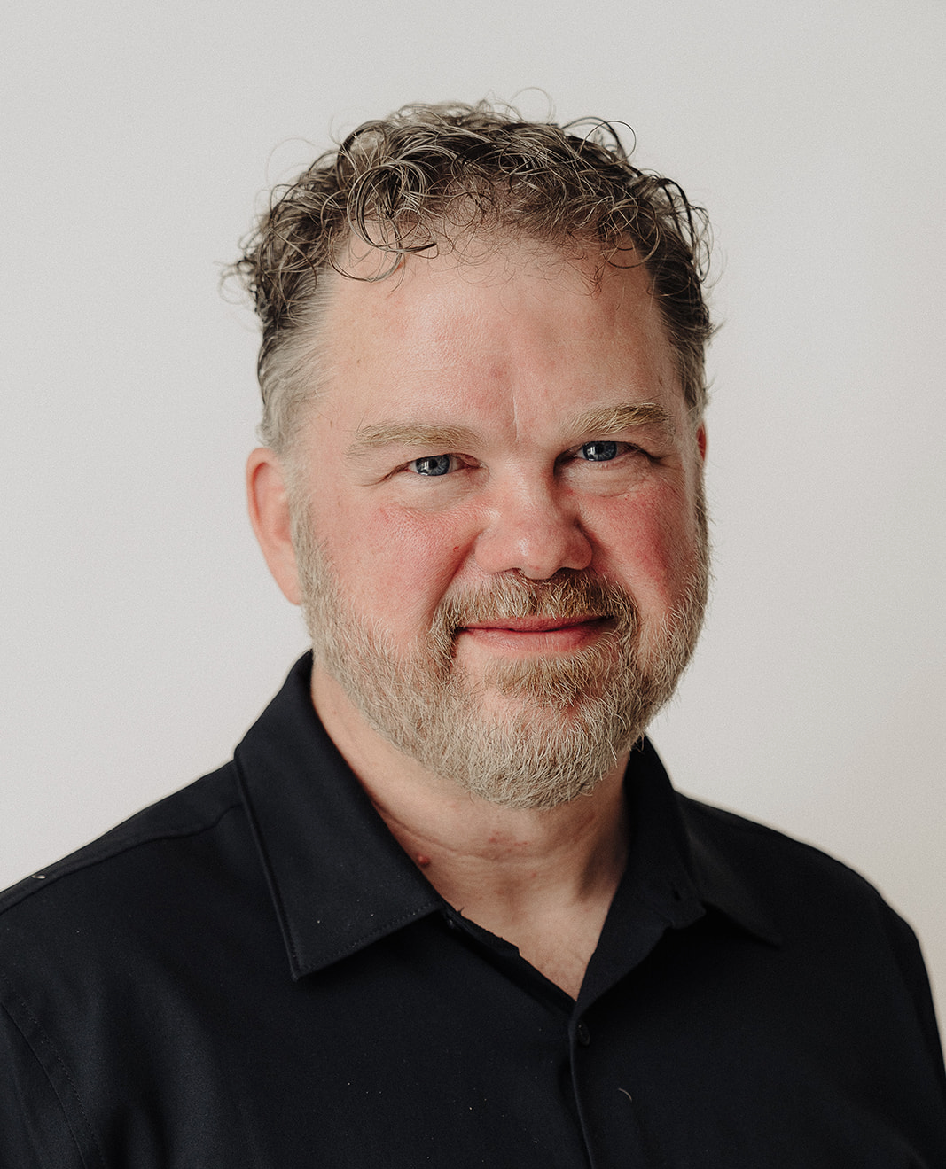 Headshot of Kevin R Scott, smiling, in a black shirt