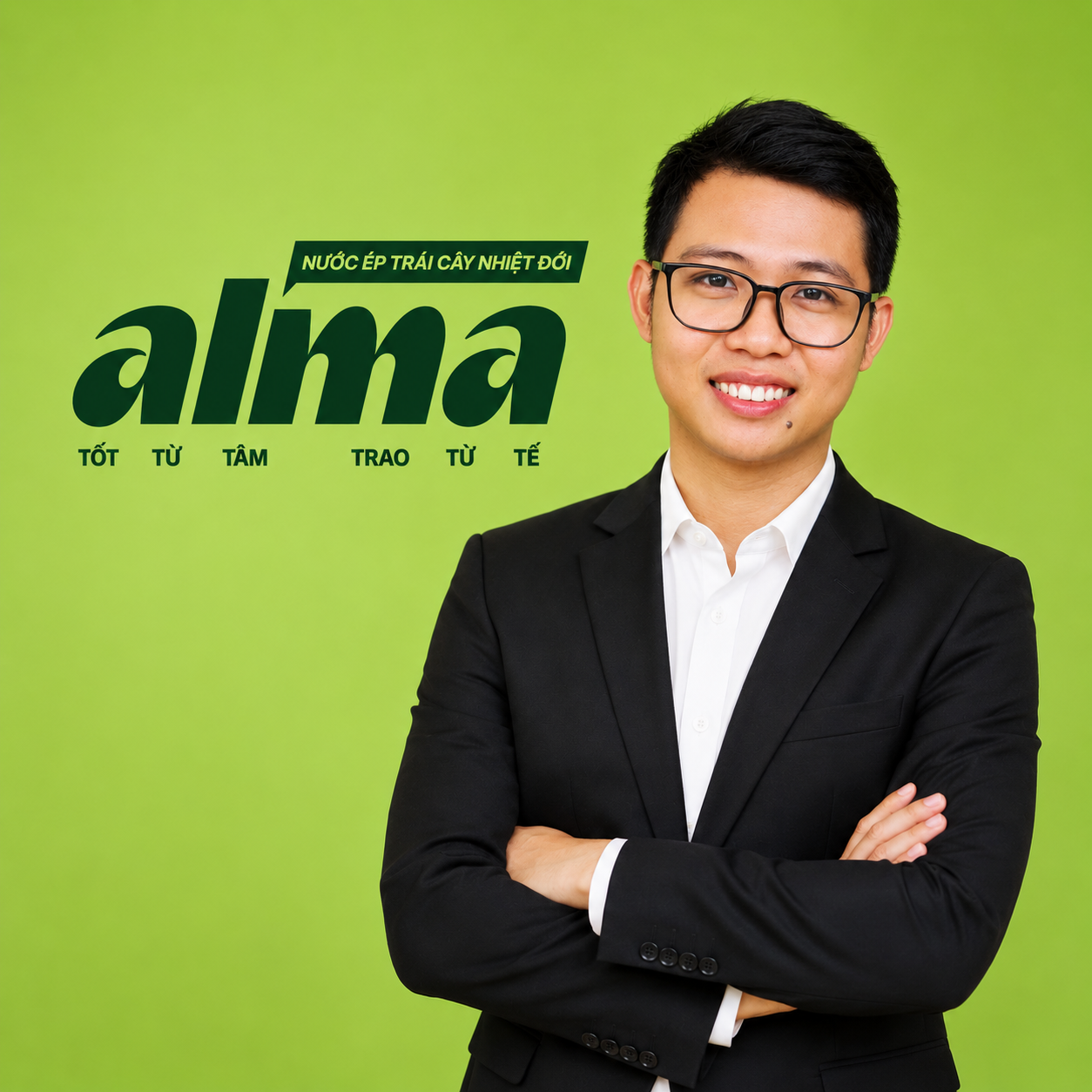 A young man wearing glasses and a black suit with a white shirt, standing with arms crossed against a bright green background, with Vietnamese text promoting an aloe vera drink.