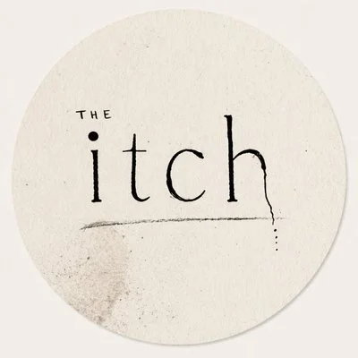 The word 'The itch' written on a circular piece of paper with a scratch mark underneath.
