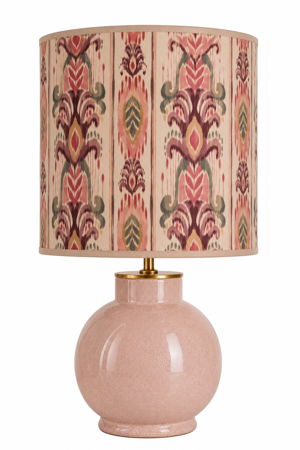 Tischlampe mit rosa Keramikbasis und einem gestreiften, bunten Lampenschirm mit floralem Muster.