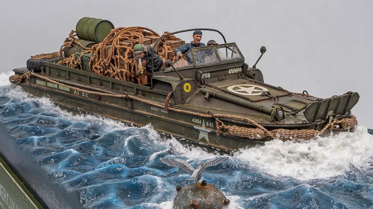 Model of a military amphibious boat (DUKW) with two figures, carrying supplies and gear, navigating through water.