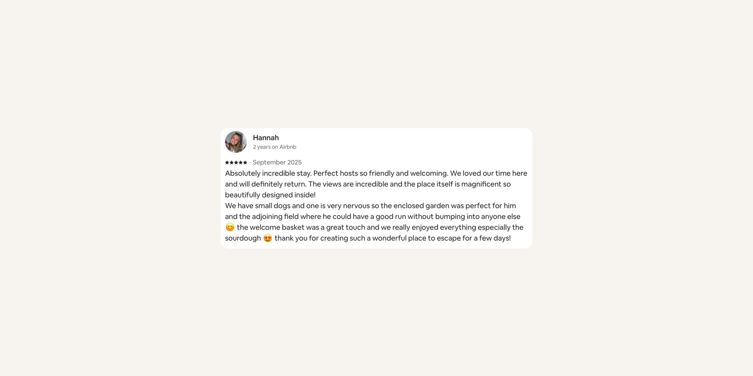 Screenshot of a Airbnb guest review by Hannah, describing her positive experience with the host, the property, the views, the garden, and the welcome basket, with emojis included.