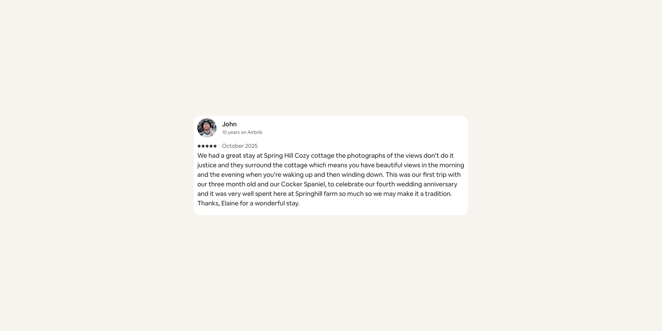 Screenshot of a customer review by John about a stay at Spring Hill Cozy Cottage, mentioning views, animals, and a wedding anniversary celebration.