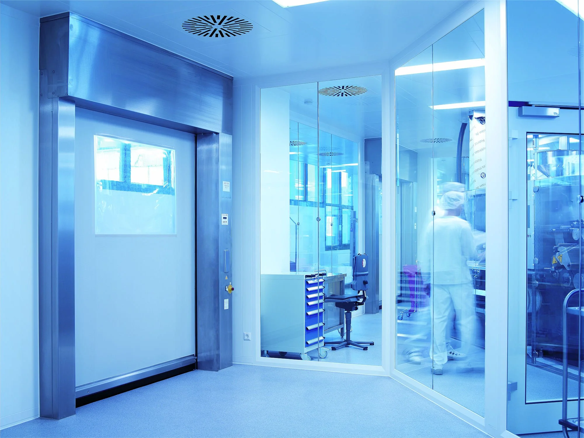High-speed cleanroom roll-up door installed in a pharmaceutical manufacturing facility with stainless steel contamination-controlled design.