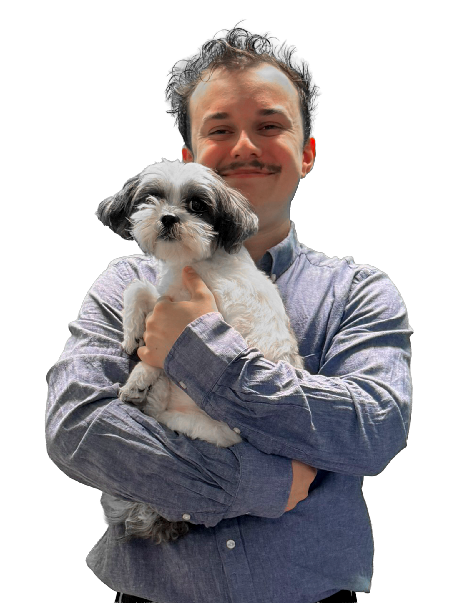 A man with curly hair and a faint mustache holding a small black and white dog. The man is smiling, wearing a gray, long-sleeved, button-up shirt. The background is unclear.