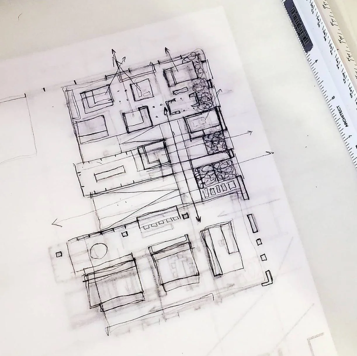 Hand-drawn architectural floor plan on paper with a ruler nearby.
