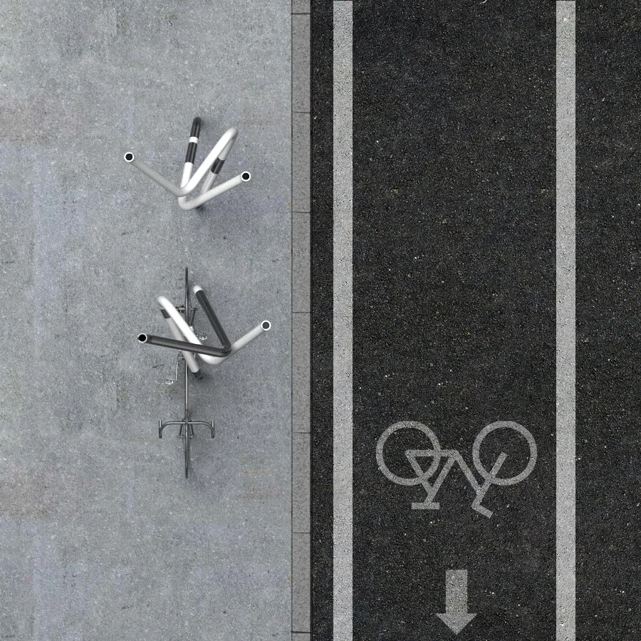 Overhead view of two stacked bicycle racks on the sidewalk next to a bike lane with bicycle symbols and directional arrow.