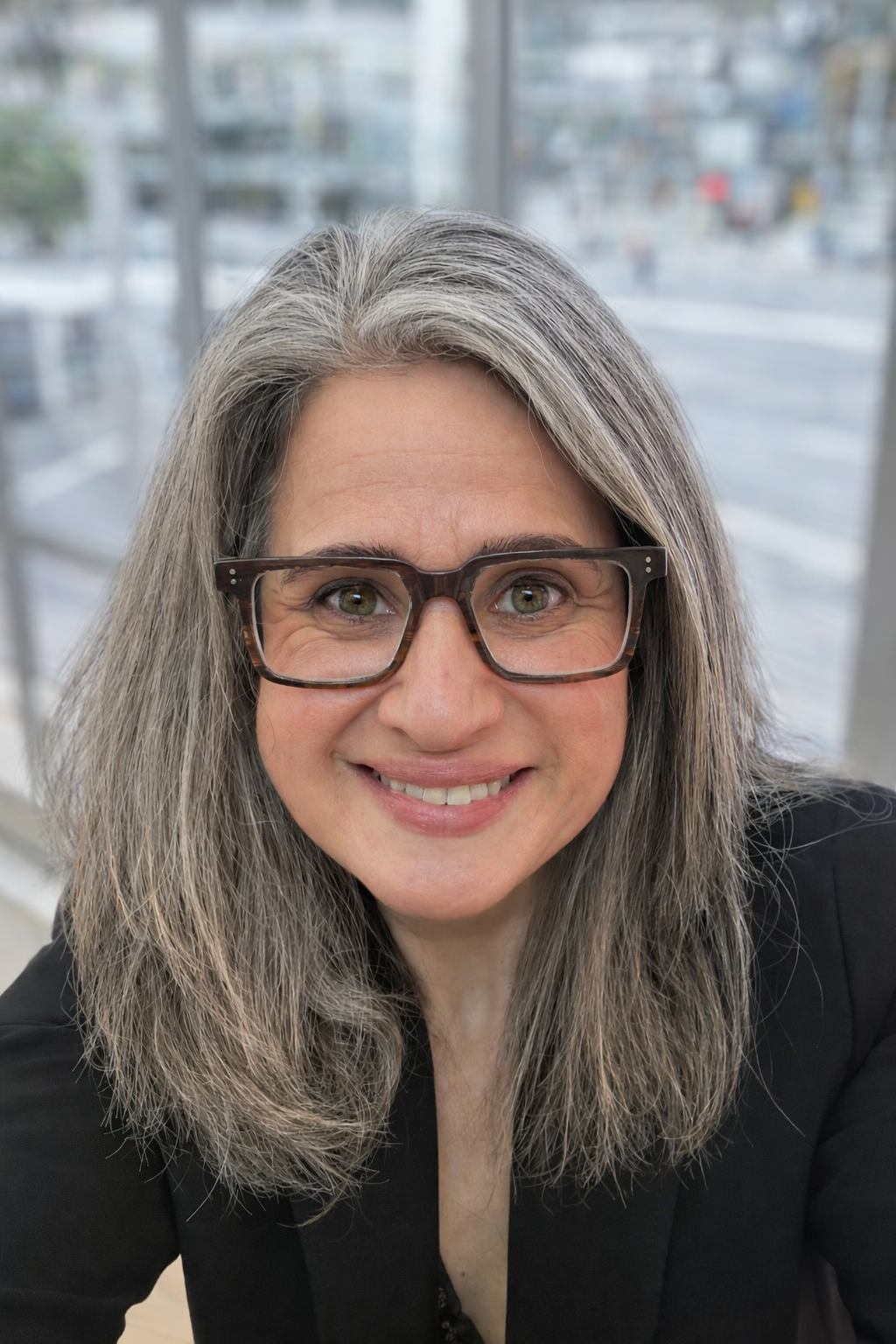 profile picture of an attractive older woman, with long silver hair and hazel eyes, wearing glasses