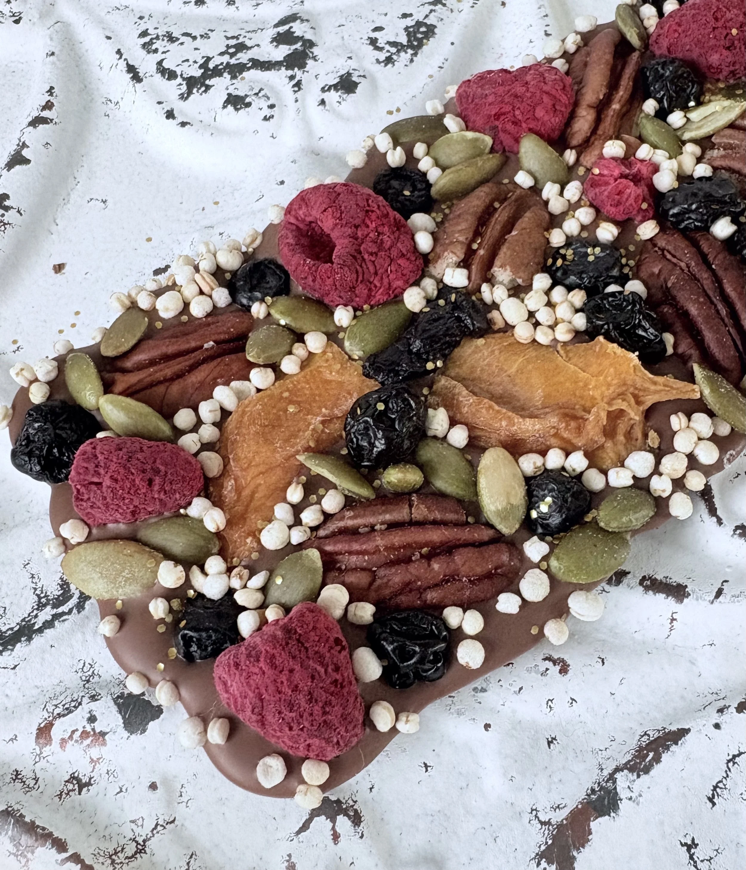 Belgian milk chocolate bark with freeze-dried raspberries, pecans, pumpkin seeds, dried blueberries, and dried mangos