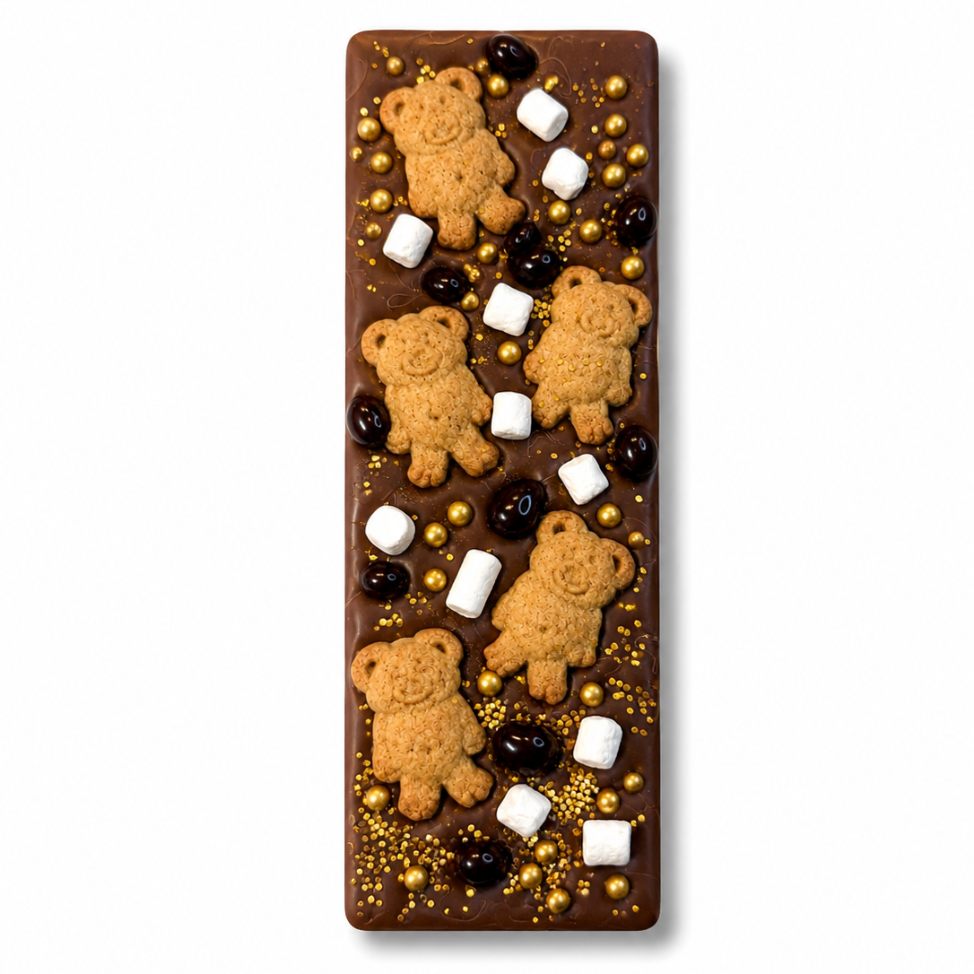 Small Belgian milk chocolate bark topped with Teddy Graham crackers, mini freeze-dried marshmallows, chocolate covered cacao nibs, and gold sprinkles