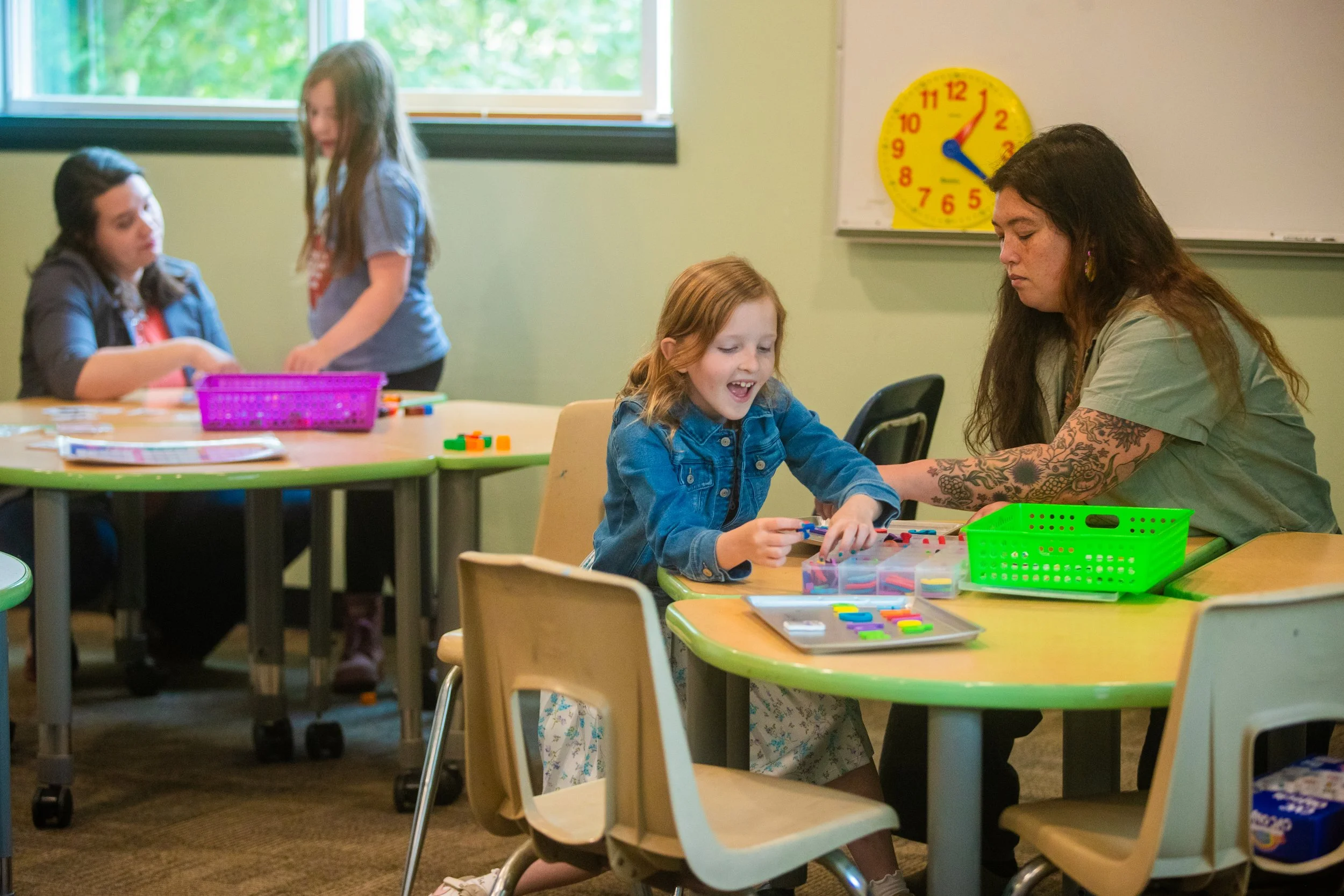 Students learn in a multi-age classroom with low student teacher ratios.