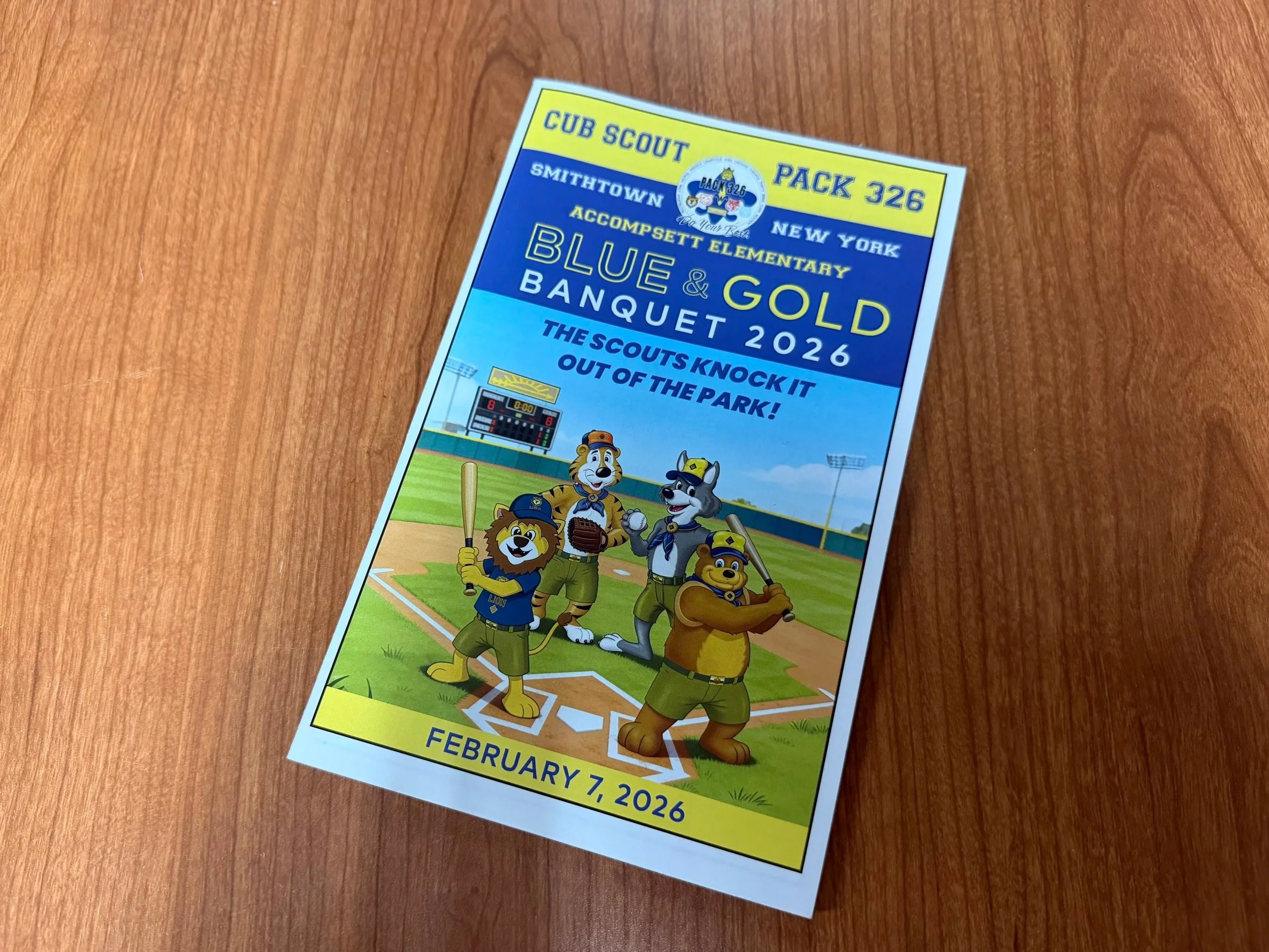 A colorful flyer features a cartoon lion and dog dressed in scout uniforms holding baseball equipment, set against a baseball field background with a scoreboard and lights.