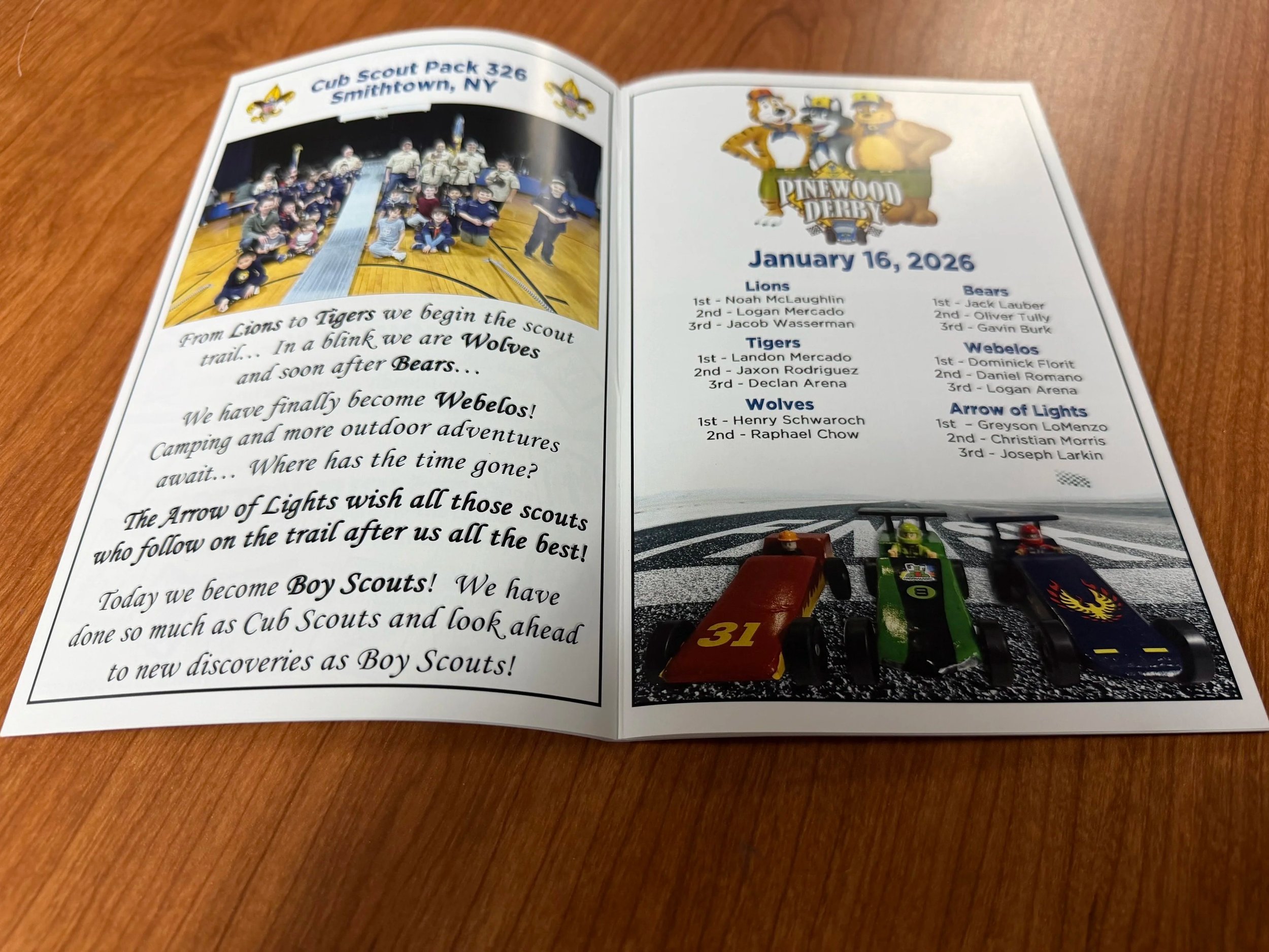 Open booklet with a group photo on the left page and a list of award winners on the right page, dated January 16, 2026