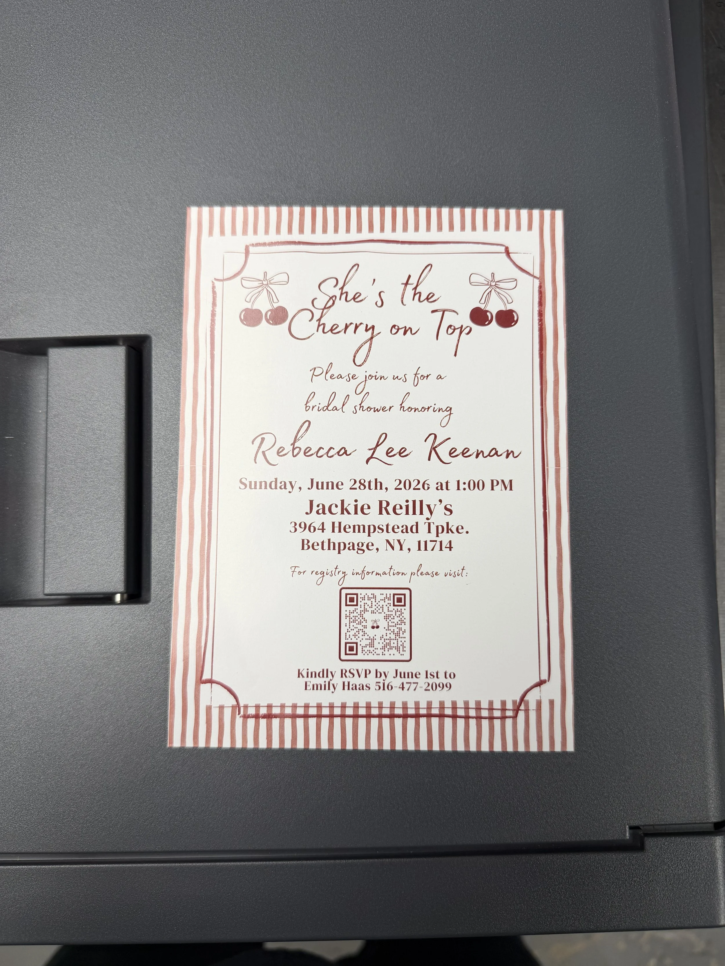 A bridal shower invitation with a cherry theme. The text includes the bride's name and details about the date, time, and location of the event. The invitation features cherry illustrations and a red and white striped border,