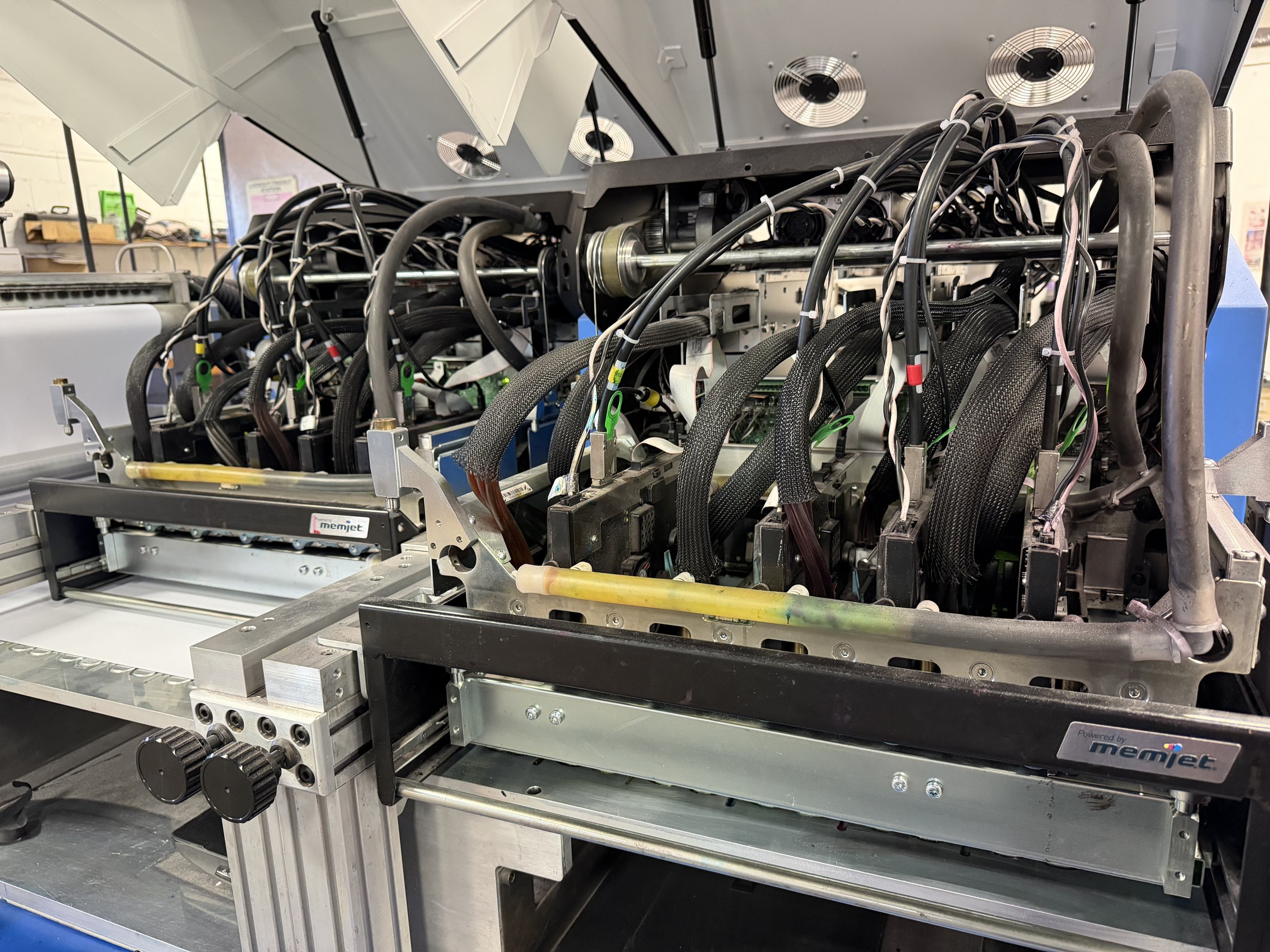 Close-up of the internal components of a mining rig or server hardware, showing multiple black cables, connectors, and circuit boards within a metallic frame.
