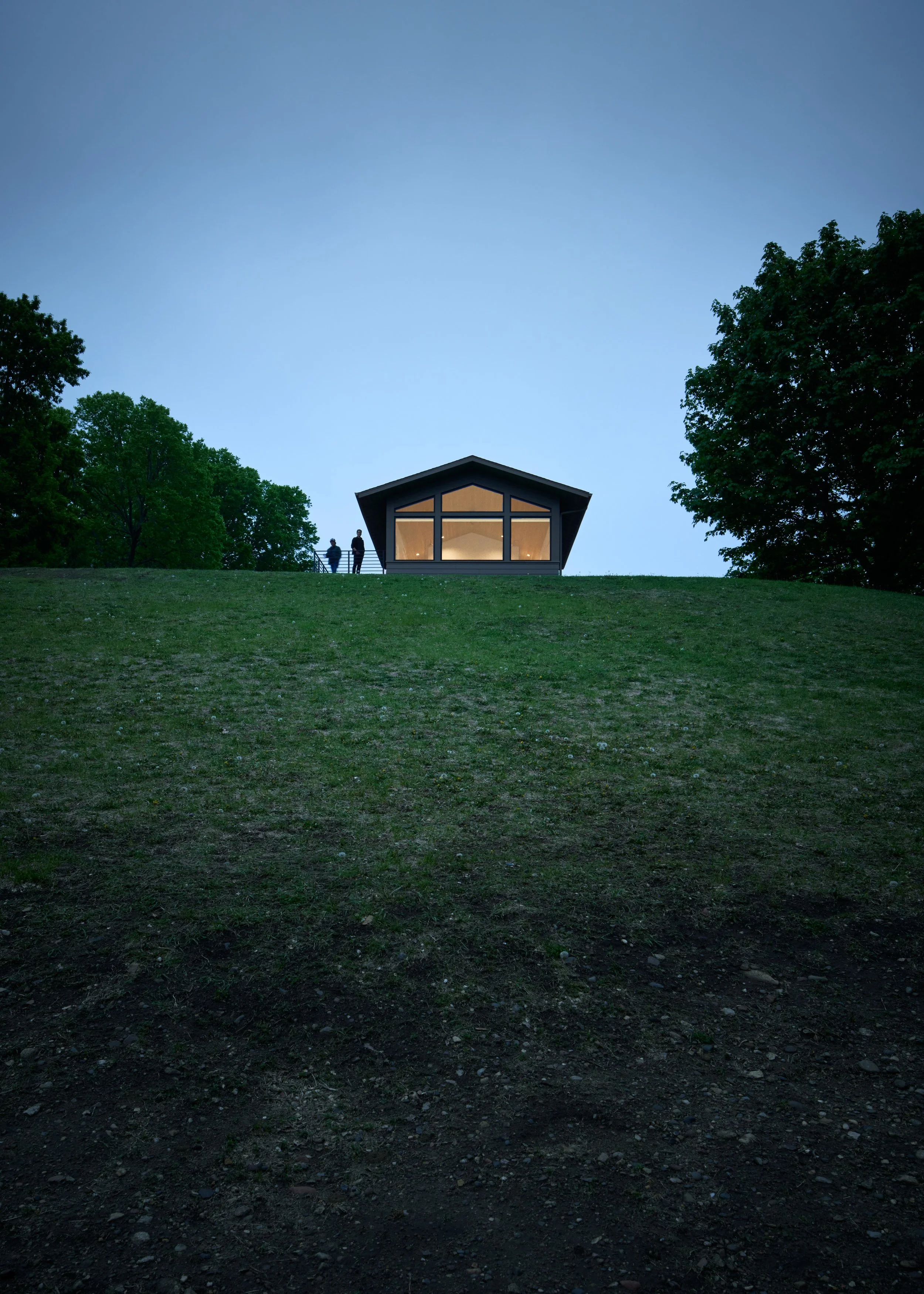 Modern custom home exterior at dusk in St. Paul with expansive lawn and contemporary architecture.