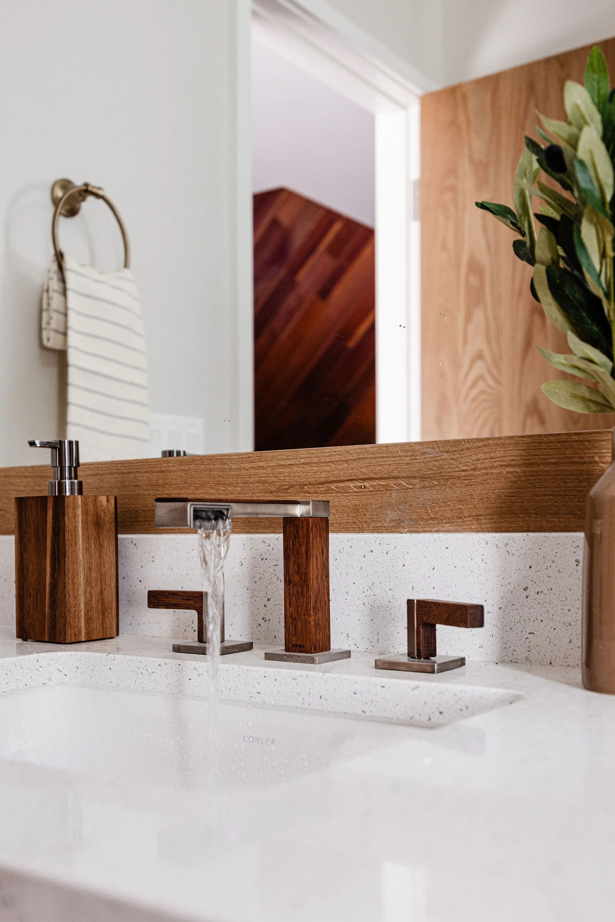 Frank Lloyd Wright inspired bathroom wood-accent faucet, quartz countertop, and minimalist finishes.