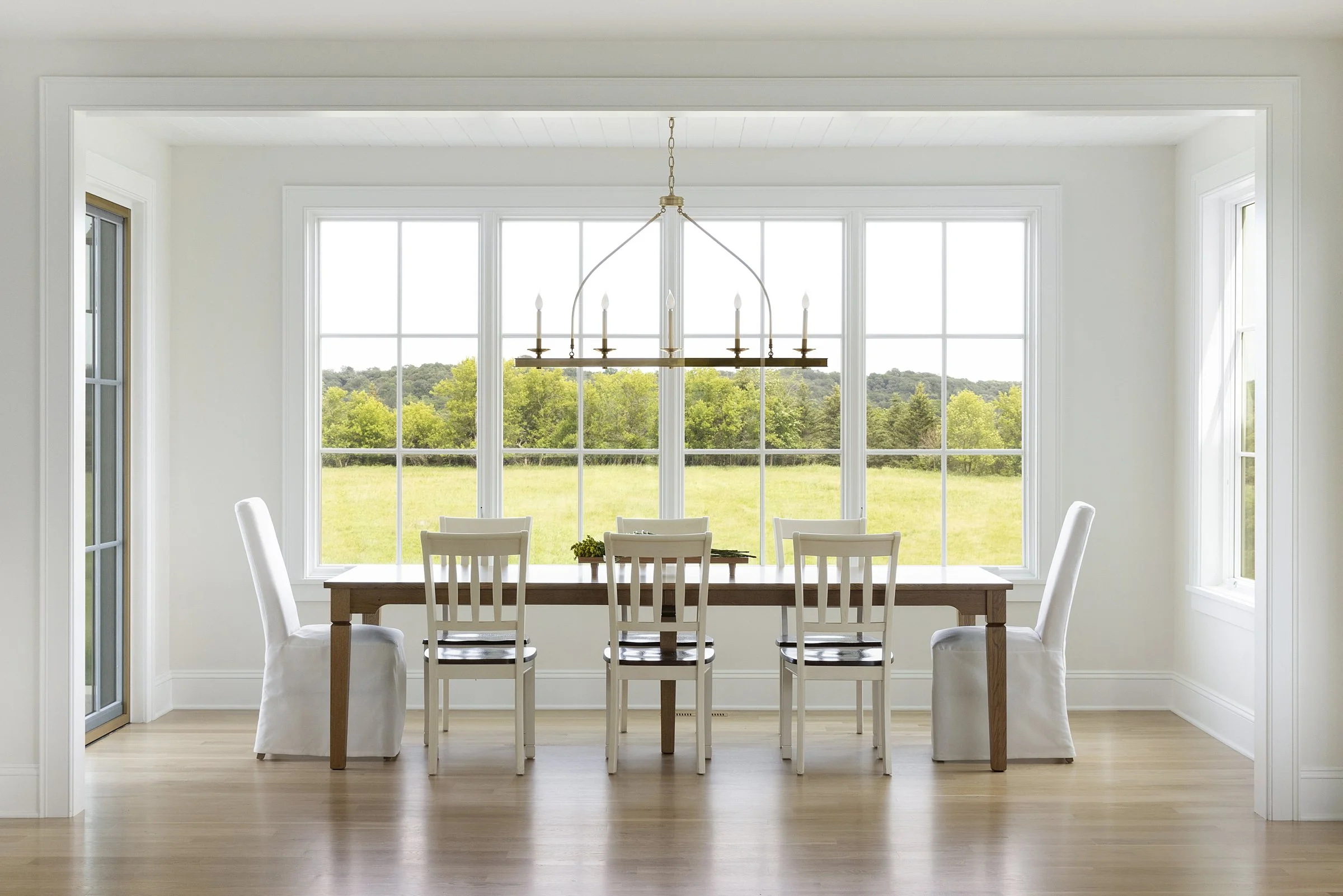 Sunlit dining area with panoramic landscape views in a custom Rochester, Minnesota home.