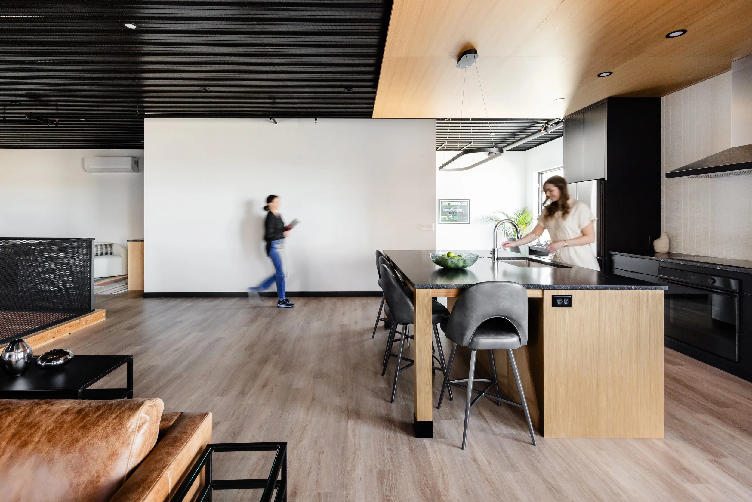 Open-concept kitchen and living area with wood ceiling detail and industrial finishes inside a Medina luxury auto condo.