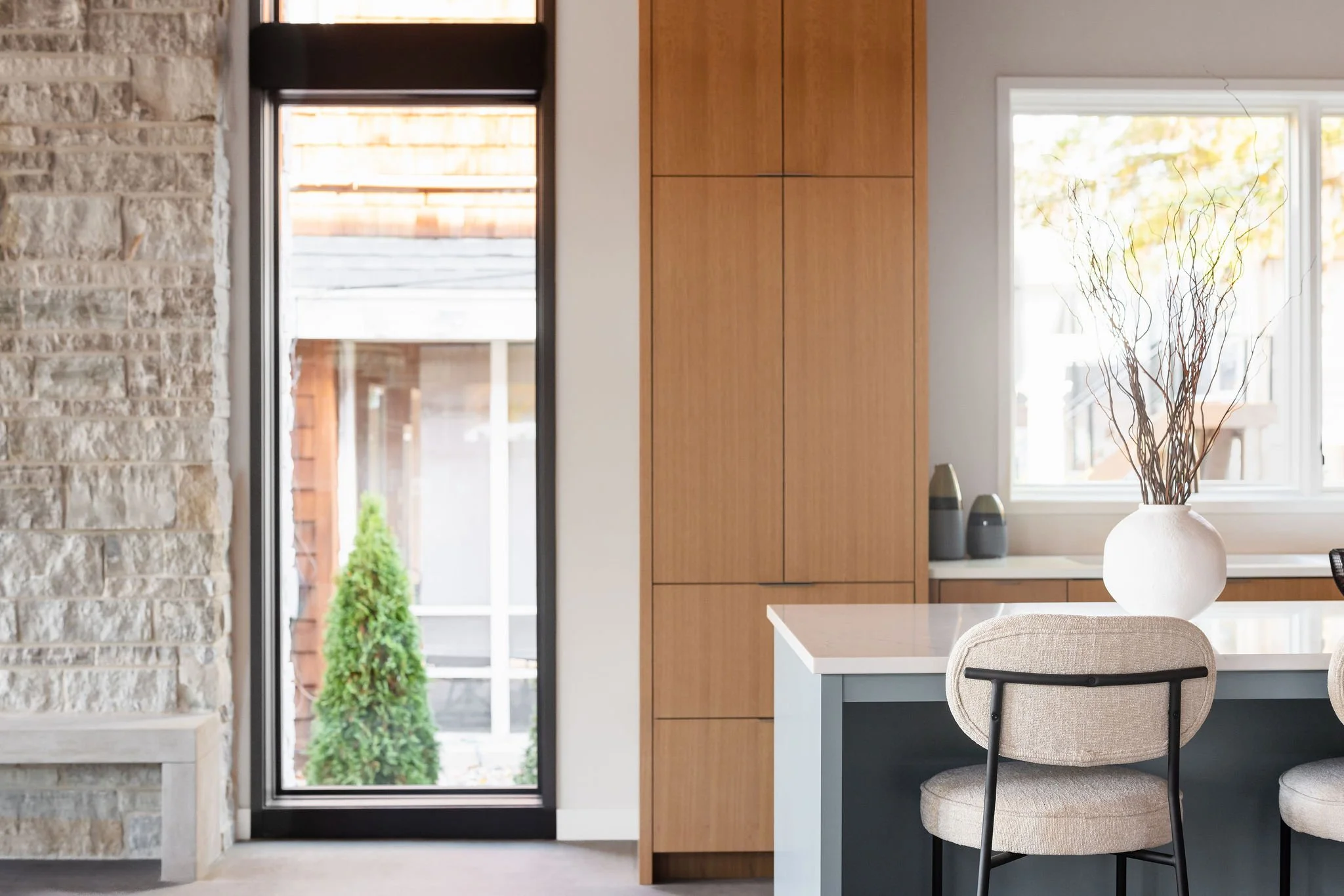 Custom kitchen cabinetry and stone fireplace detail crafted with natural materials and clean architectural lines.