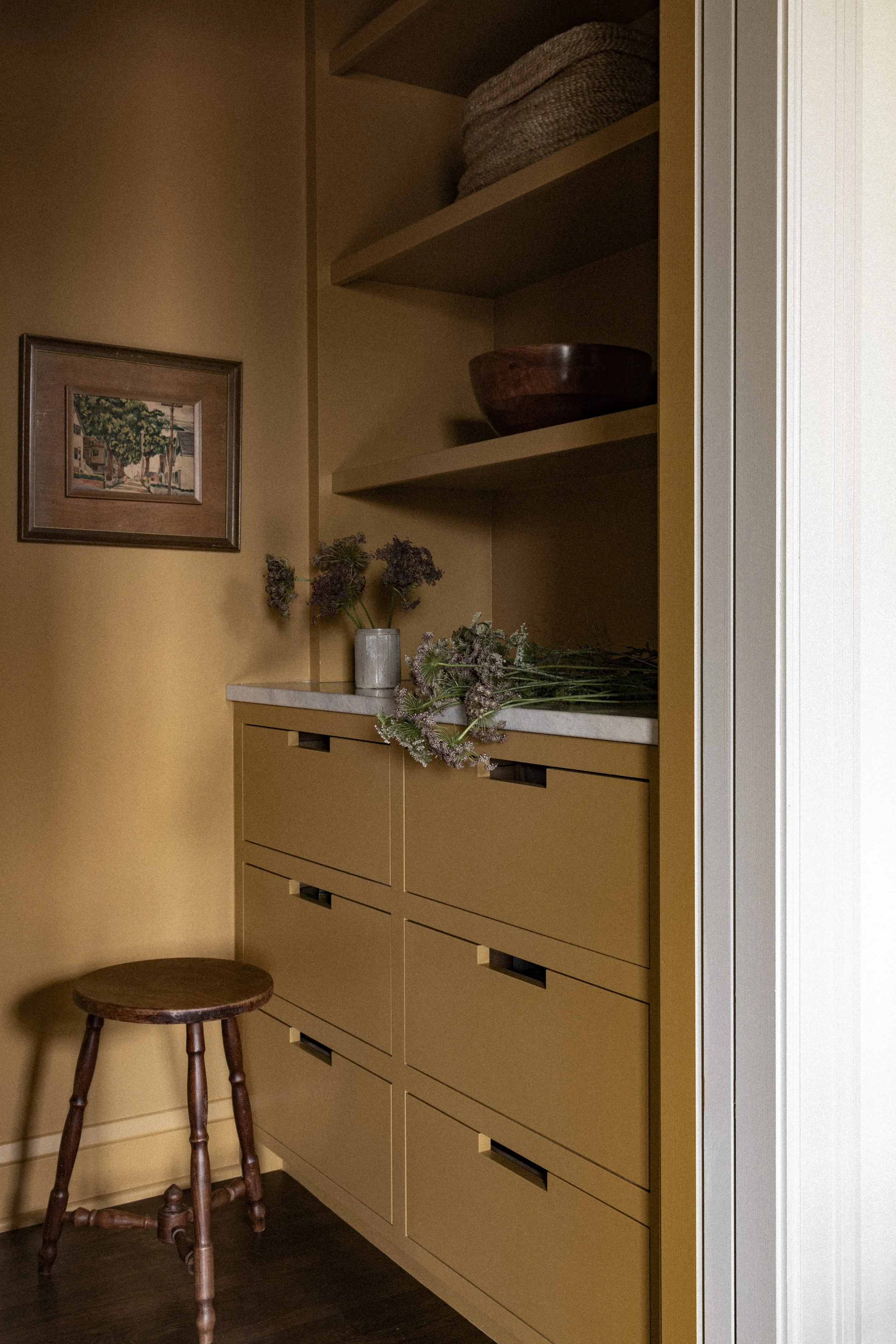 Custom scullery and pantry storage in a Minneapolis remodel with warm cabinetry, open shelving, and built-in drawers.
