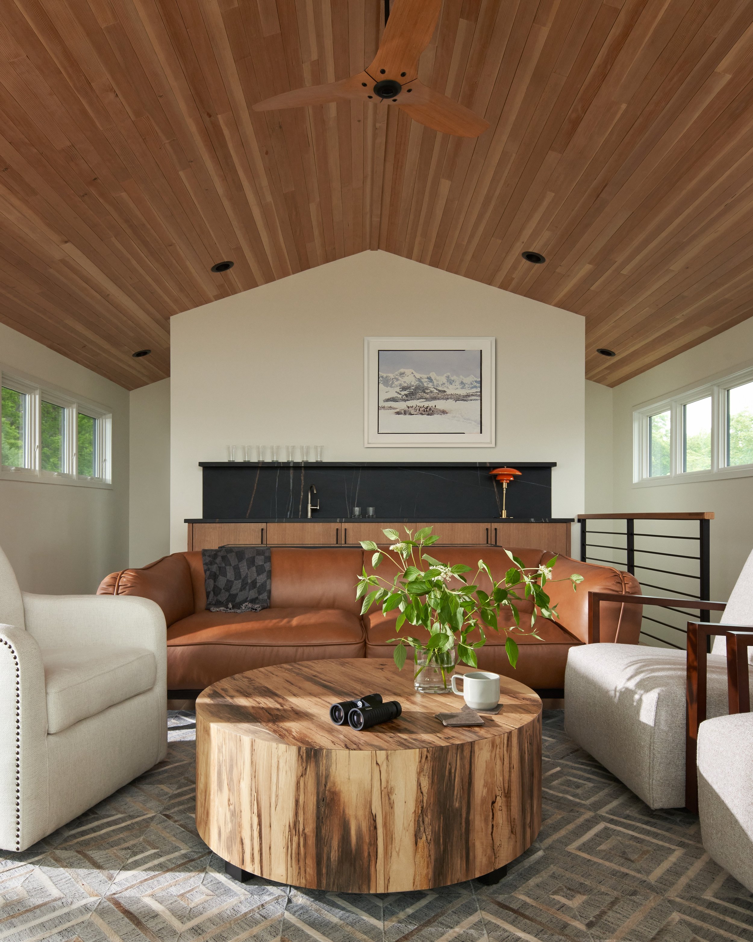 Sitting area with vaulted cedar ceiling, custom millwork, leather sofa, and built-in bar at Parkway Heritage, a St. Paul home renovation by Karl Adalbert Architecture + Design.