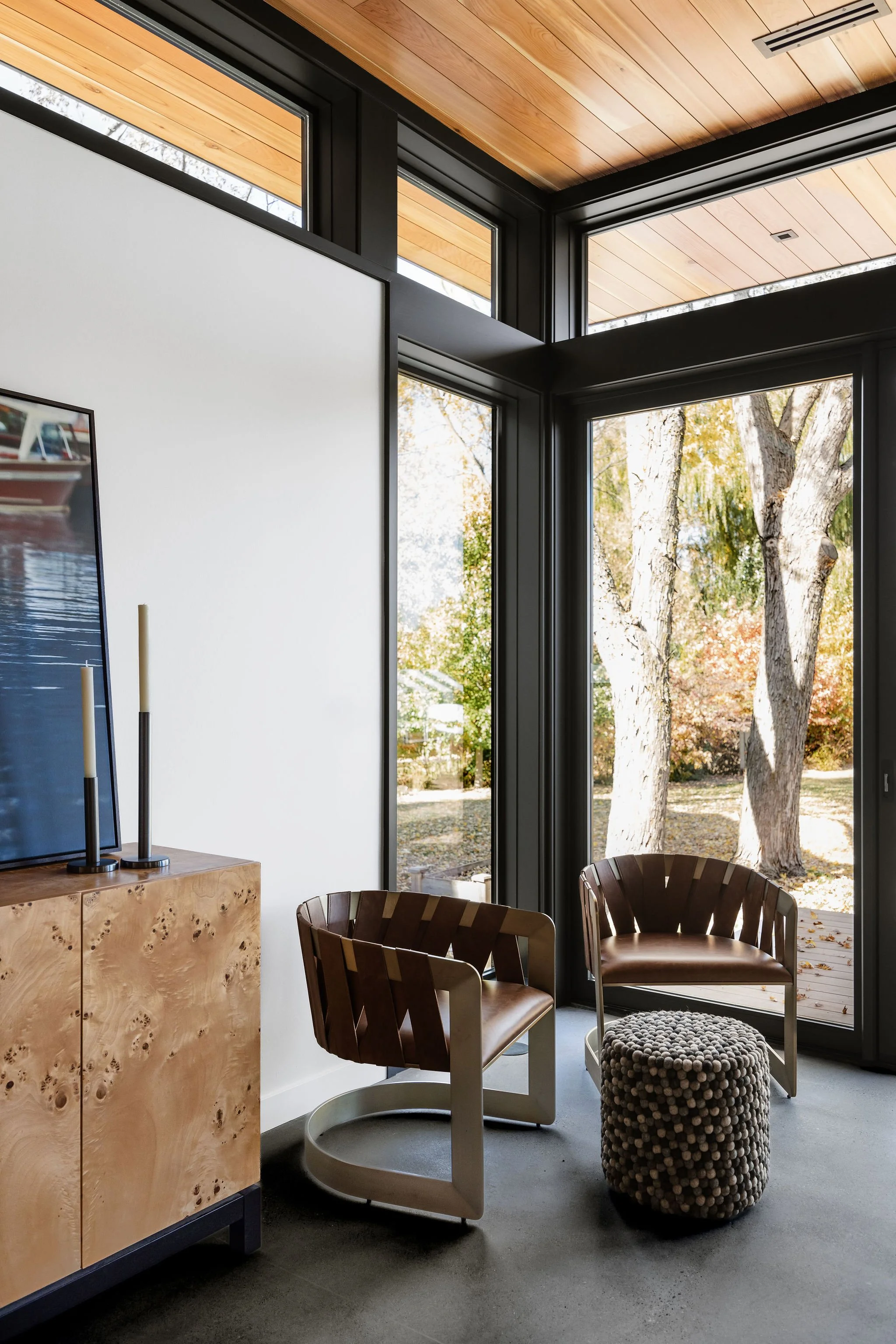 Contemporary window corner detail showcasing black-framed glazing and wood ceiling finishes.