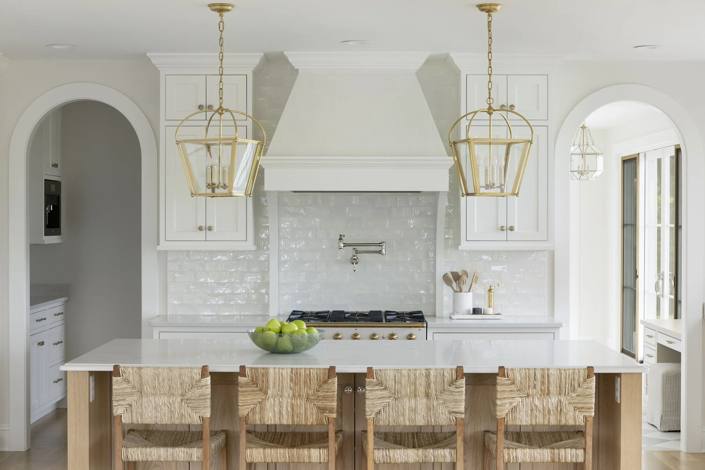 Custom kitchen island with woven counter stools, white cabinetry, and warm natural materials in a Rochester, Minnesota home.