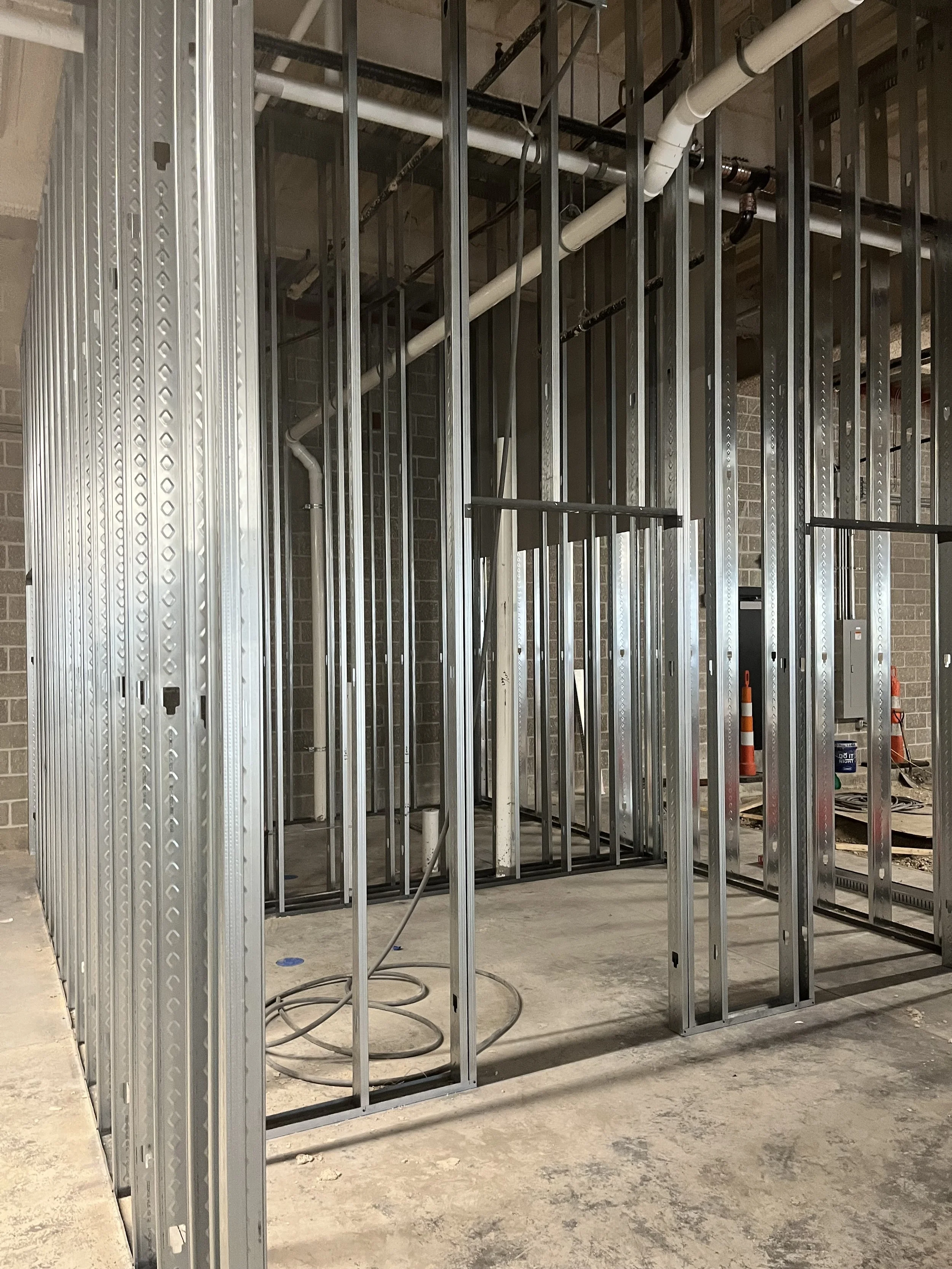 Construction site with metal framing and pipes for interior building walls.