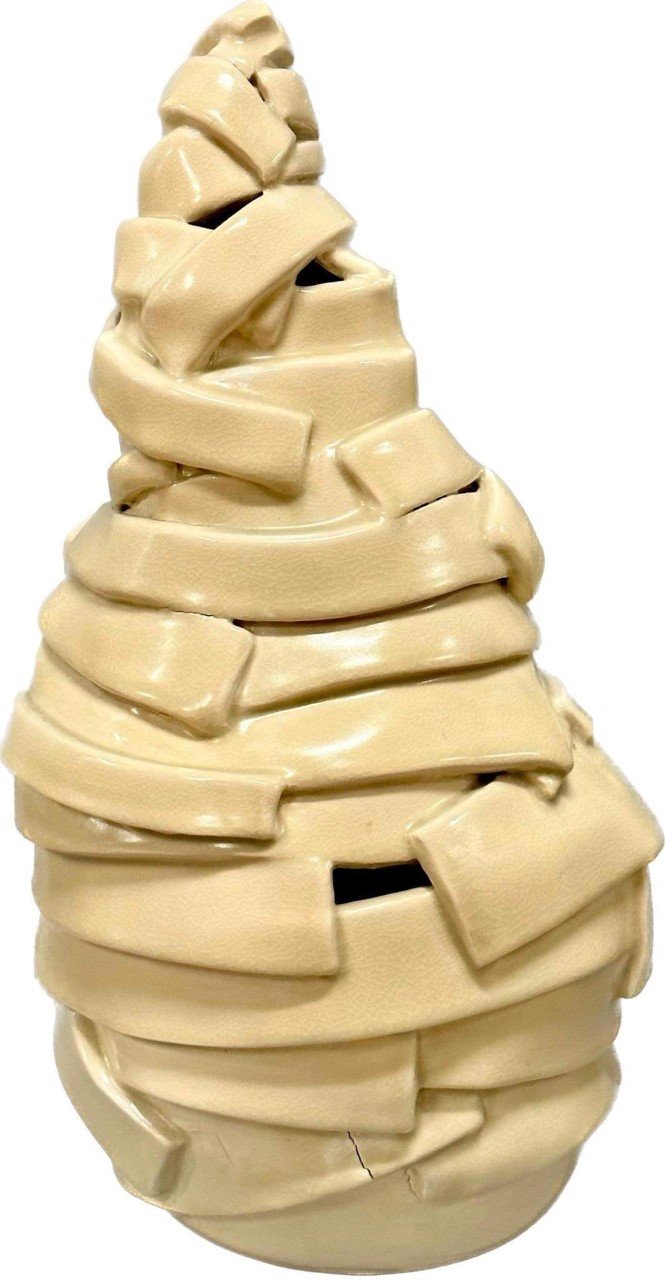 A sculpture made of stacked, irregularly shaped beige pieces resembling an abstract form.