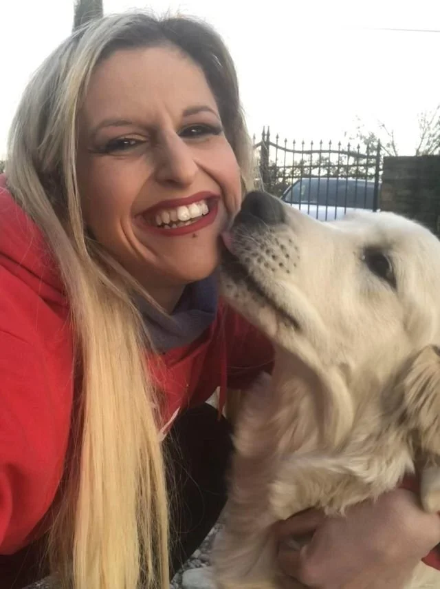 Donna sorridente con un cane golden retriever all'aperto