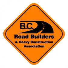 Orange diamond-shaped road sign with black text and graphics for B.C. Road Builders & Heavy Construction Association, featuring a winding road graphic.
