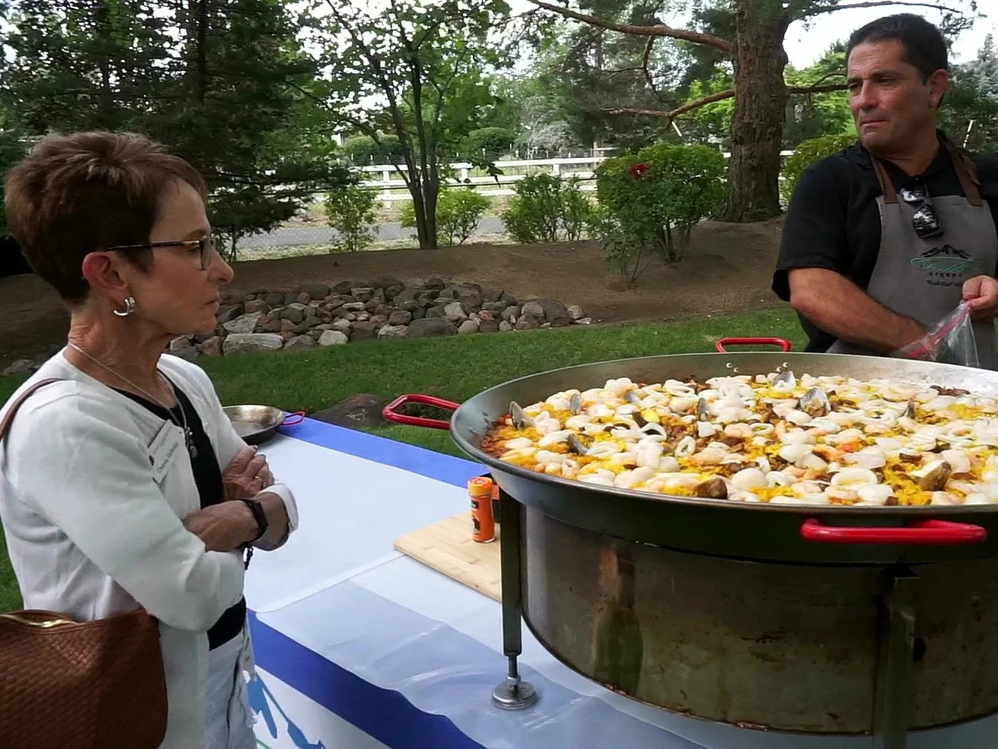 Paella chef talking with a guest while cooking at a Reno event