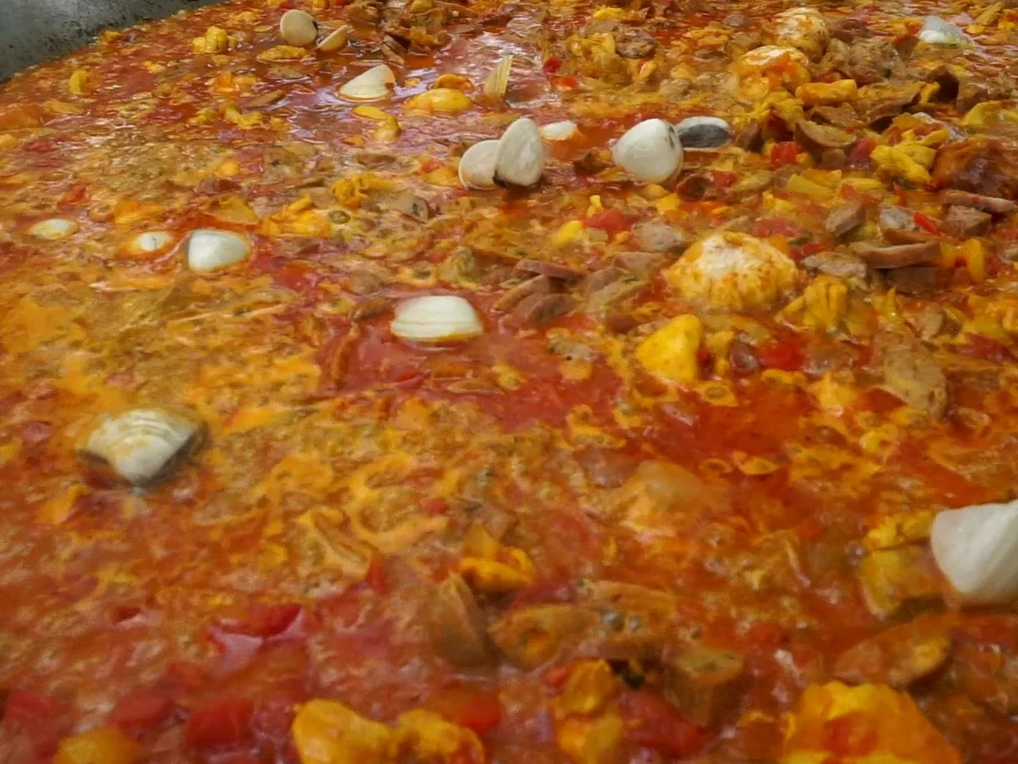 Traditional paella simmering with saffron broth, cooked fresh on site