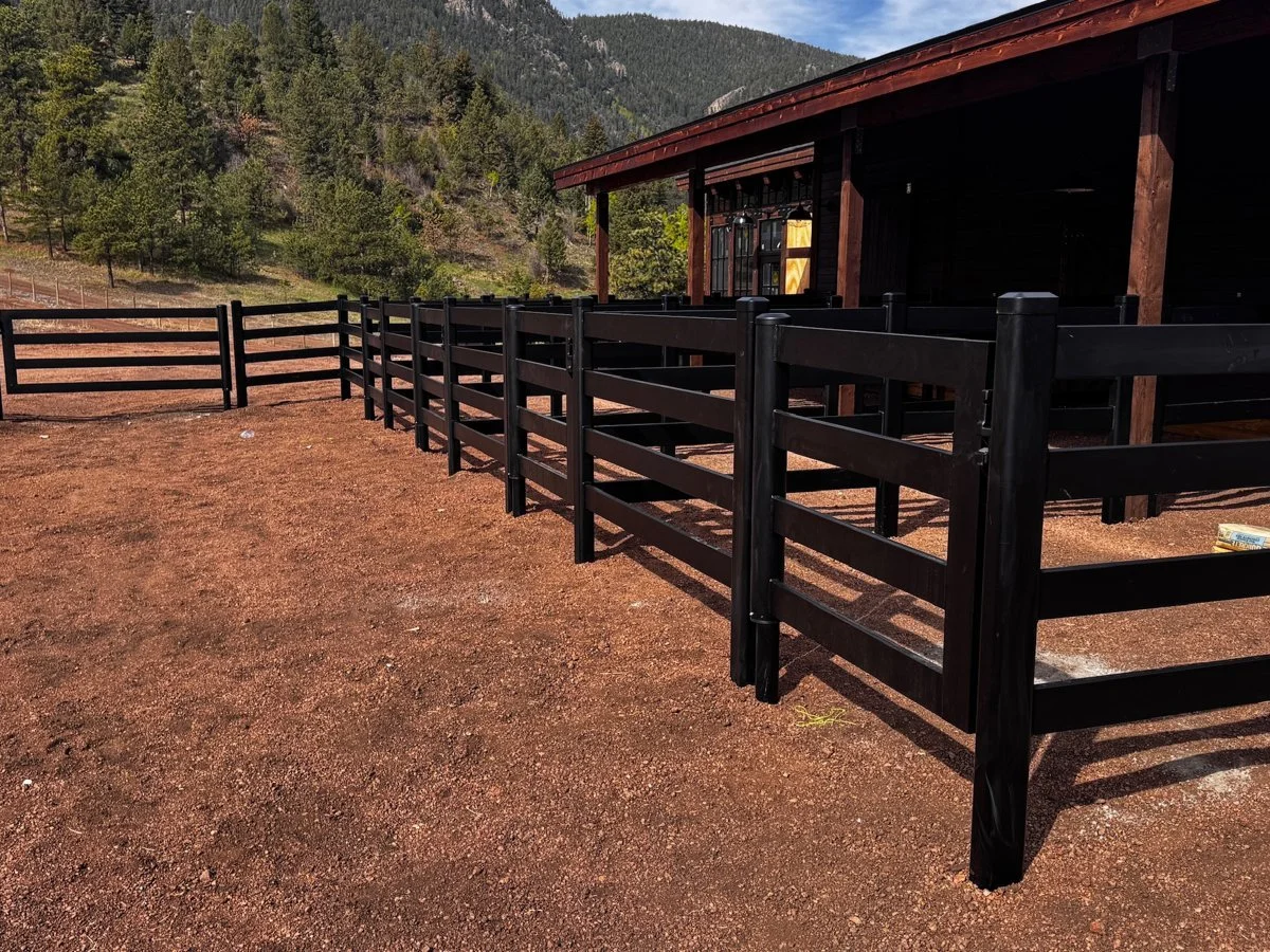 Black Buckley steel horse fence near a barn