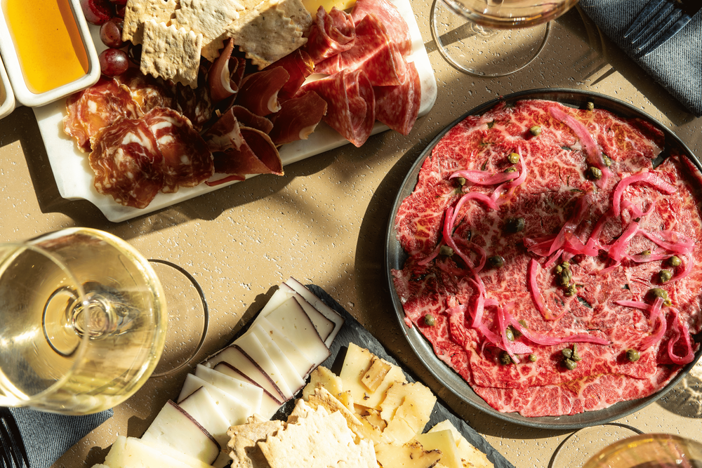 Charcuterie board with a glass of white wine