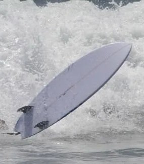 Surfboard crashing into waves in the ocean
