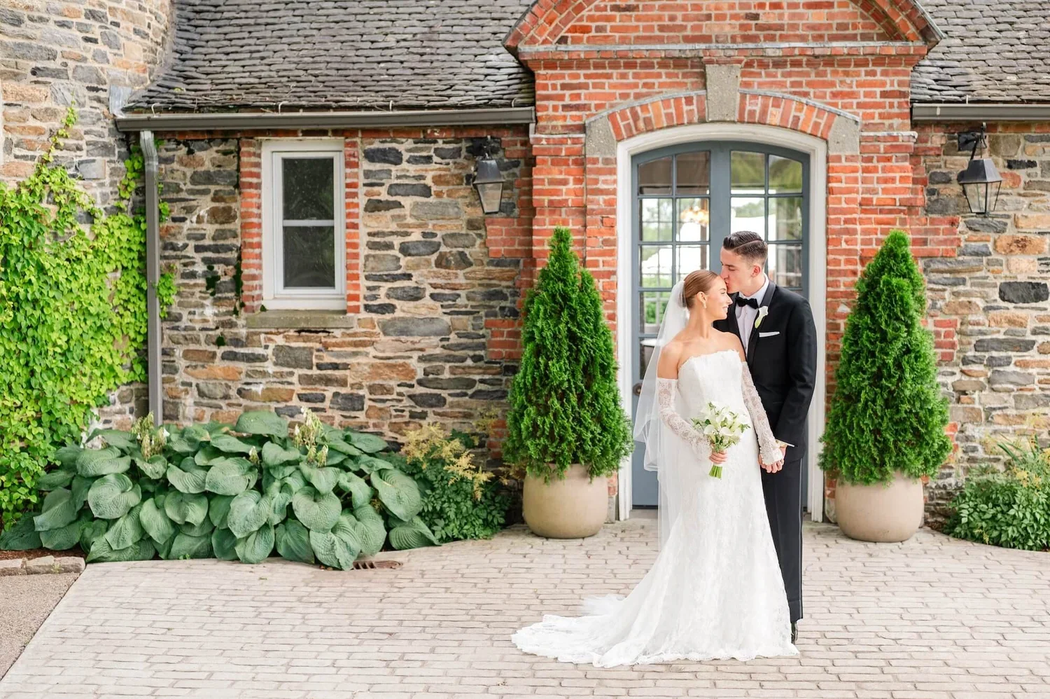 Bride and Groom Outside a Brick and Stone Wedding Venue at a Wedding Planned by Faith Ferguson Productions